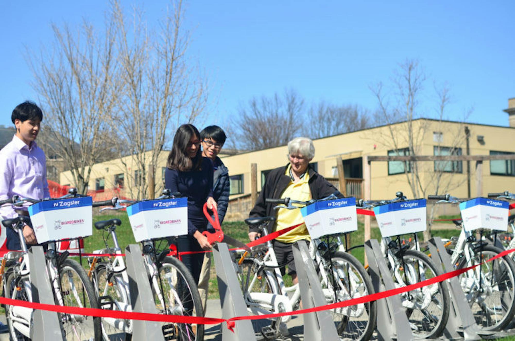 Students participate in ribbon cutting for the launch of Big Red Bikes on Saturday.