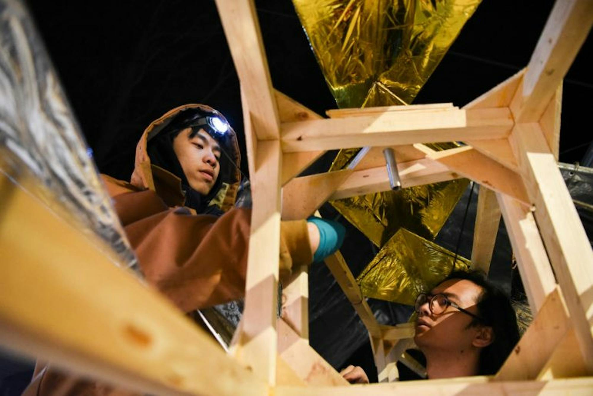 Alexander Kyaw ’22 (left) zip ties a scale to a segment of the tail.
