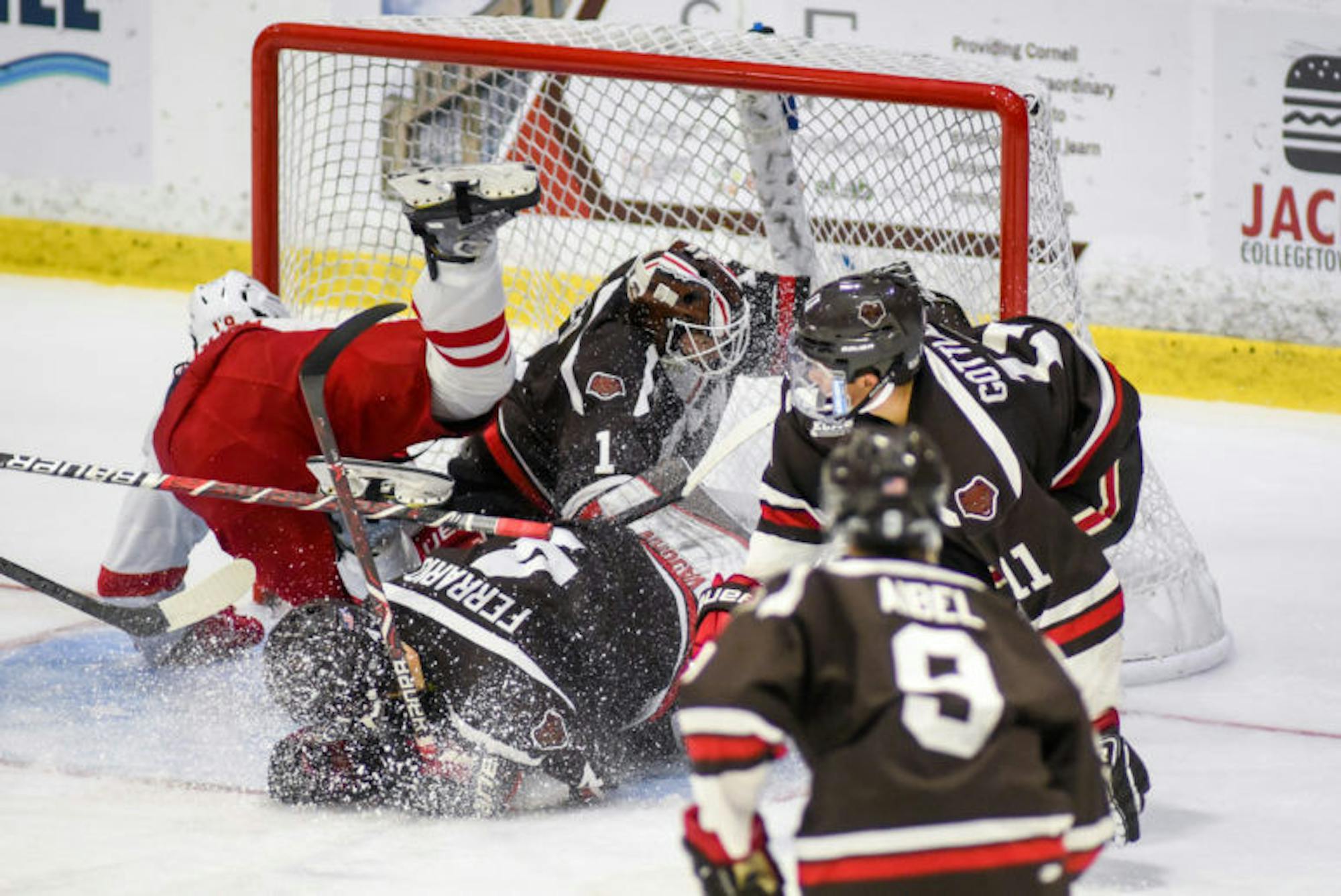 Freshman forward Michael Regush takes a fall after driving hard to the net to score his first collegiate goal, putting Cornell up 2-1 over Brown. The Red held the lead for the remainder of the game, claiming a 3-2 victory to improve to 2-0 in ECAC play. (Boris Tsang / Sun Assistant Photography Editor)
