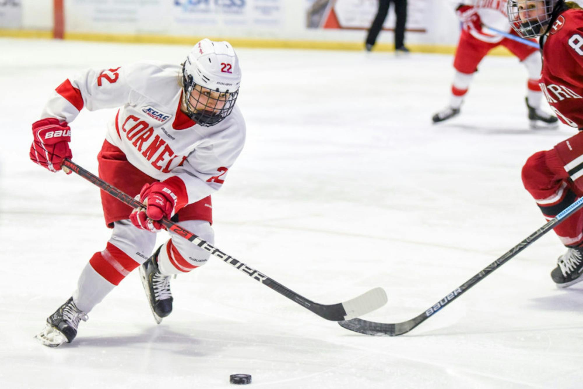 Junior forward Maddie Mills fights for the puck at the women's ECAC semifinals against Harvard on Saturday. After securing a 4-0 win, the Red is taking on Princeton today at the ECAC championship in Lynah Rink. (Boris Tsang/Sun Photography Editor)