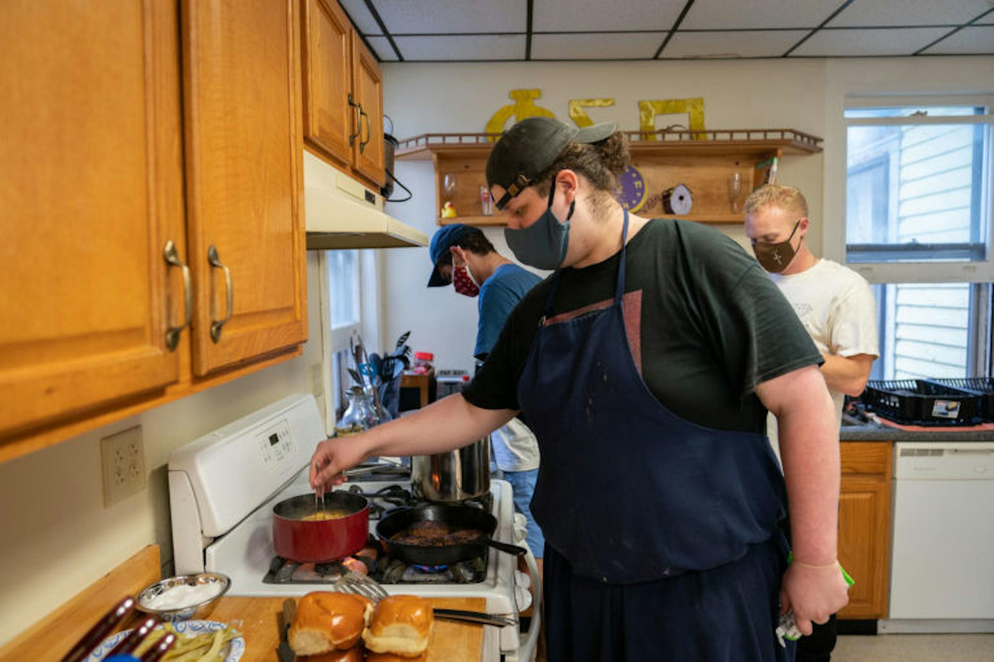 Bobby works on some burgers and noodles at the stove. (Ben Parker/Sun Assistant Photography Editor)