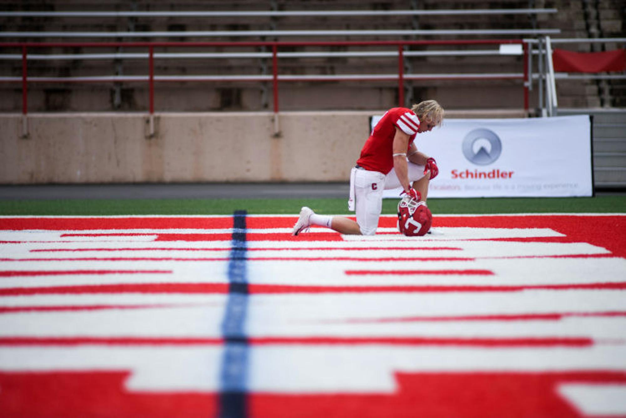 Senior running back J.D. PicKell prays before the game against Harvard on Saturday. (Boris Tsang / Sun Assistant Photography Editor)