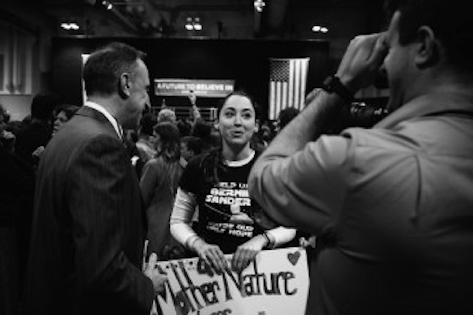 A woman at the rallies carries a sign reading,