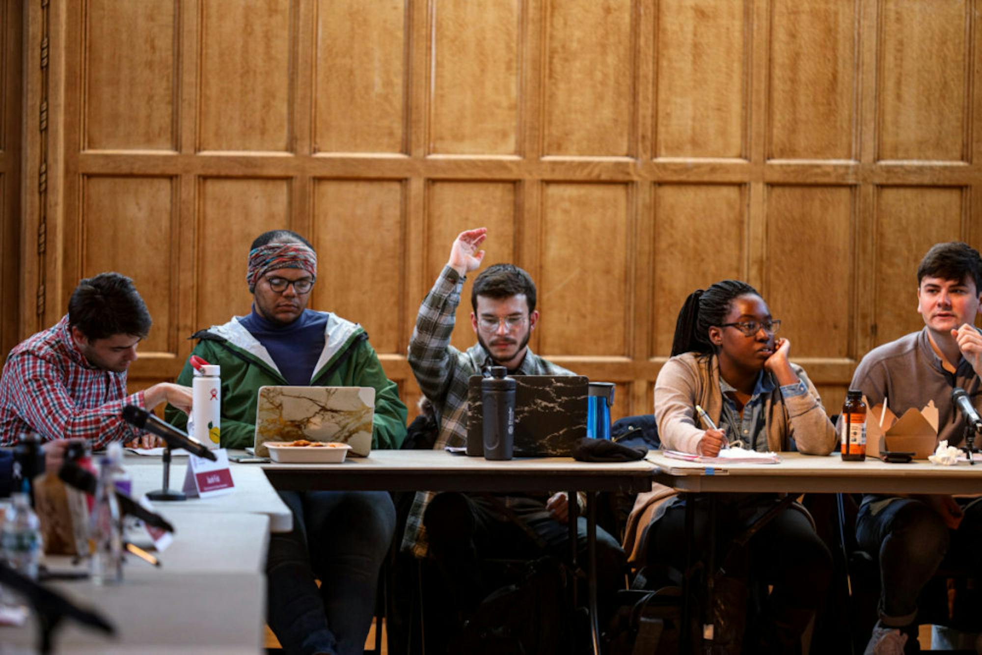 A Student Assembly member raises his hand at a meeting in Willard Straight Hall on Thursday. The Student Assembly unanimously voted against the university's proposal to rebrand HumEc as the School of Public Policy. (Michael Wenye Li/Sun Senior Photographer)