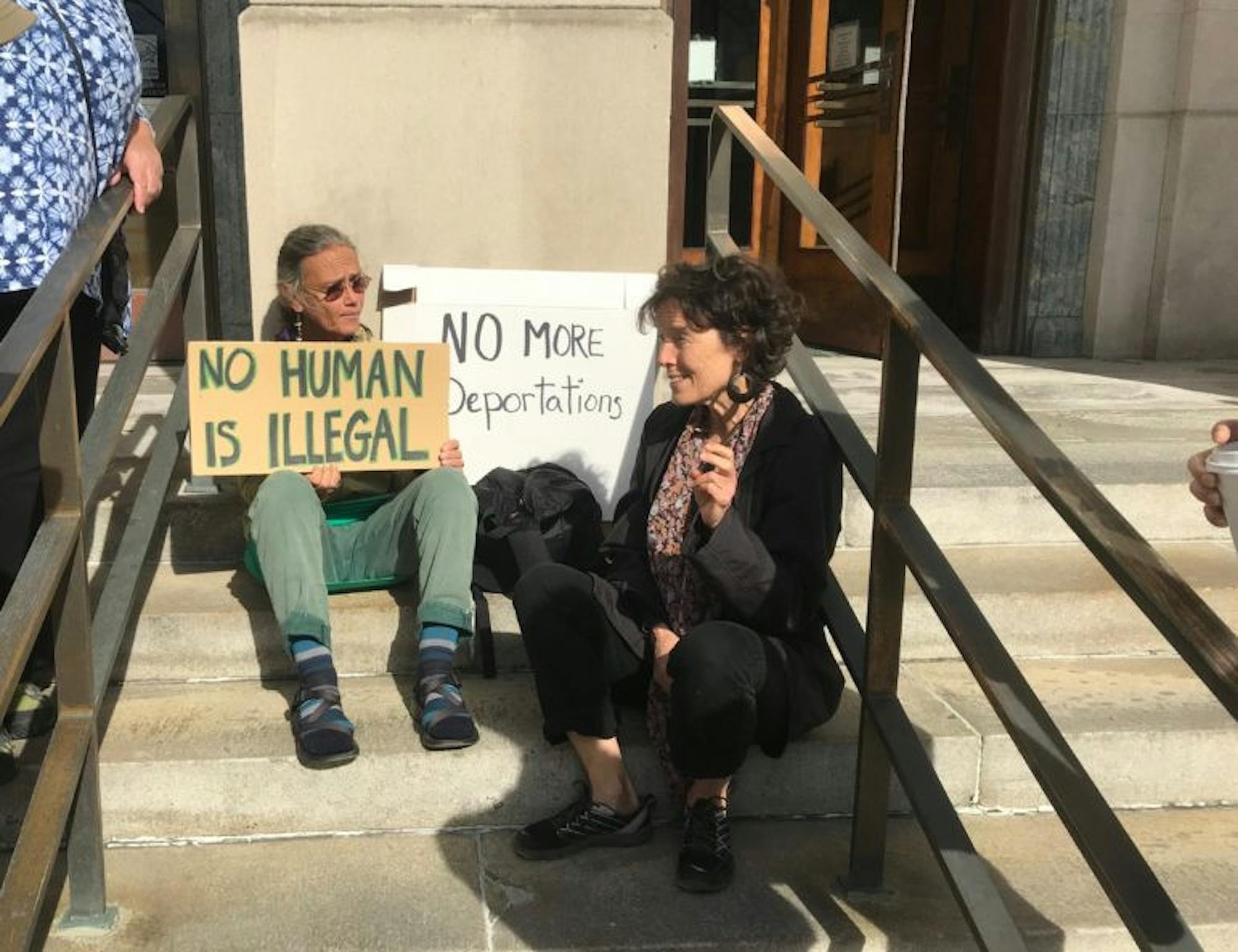 Two of about a dozen supporters of Guzman-Lopez sit outside of the U.S. District Court for the Northern District of New York in Binghamton on Friday after the 32-year-old was sentenced to time served.