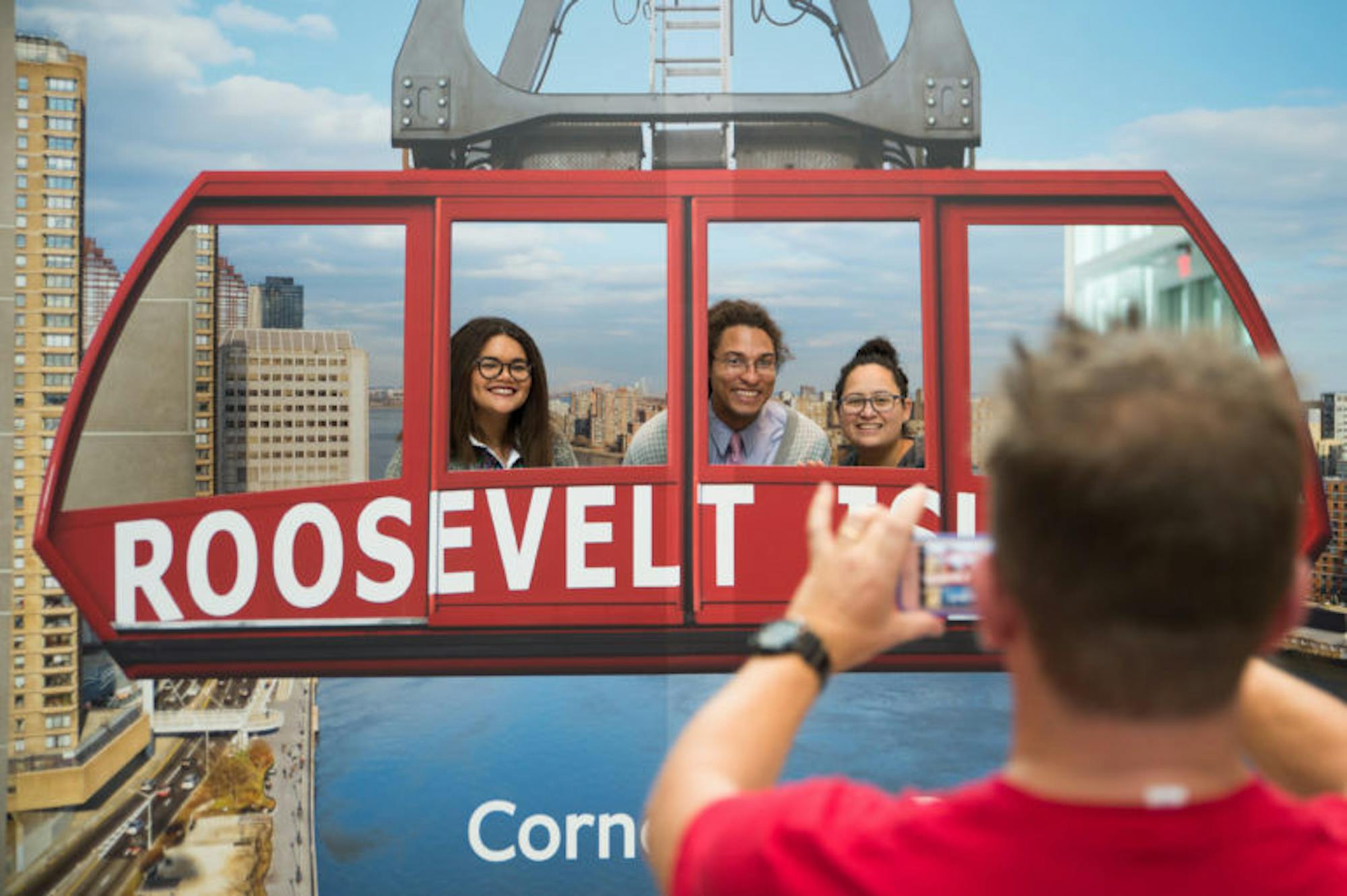 Amanda Williams '17, Reid Palmer, and Erin Rodriguez, workers in the College of Business Admissions Office, pose for pictures to commemorate the opening and dedication of Cornell Tech in New York City, September 13th, 2017. (Cameron Pollack / Sun Photography Editor)