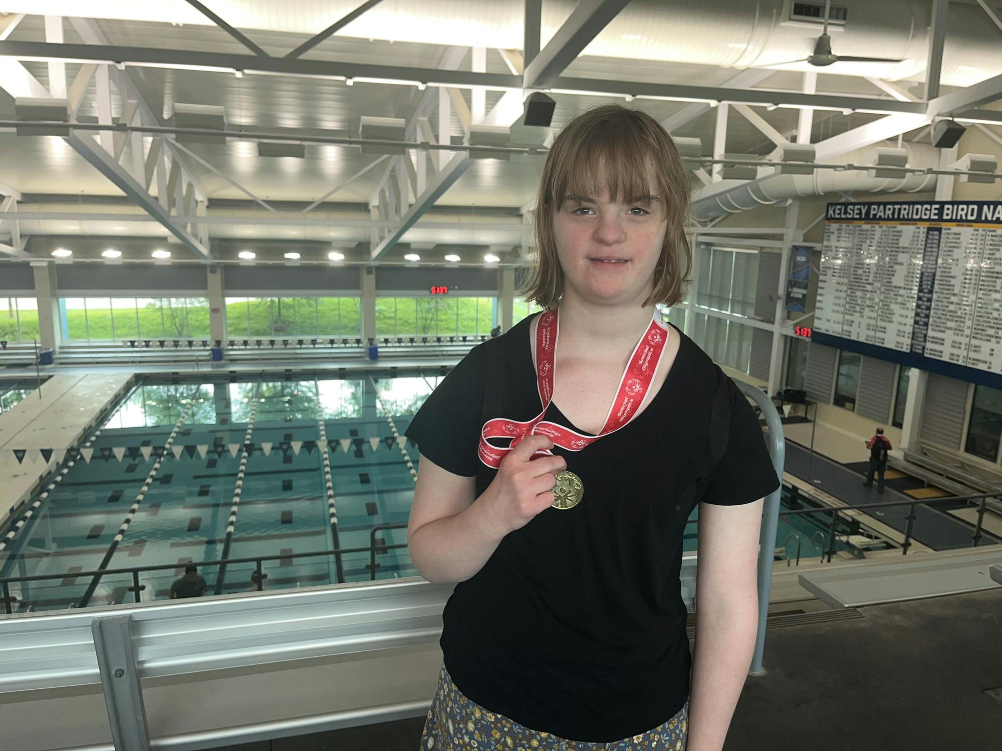 Penny Rigdon stands proudly in front of the pool she competed in earlier in the day.