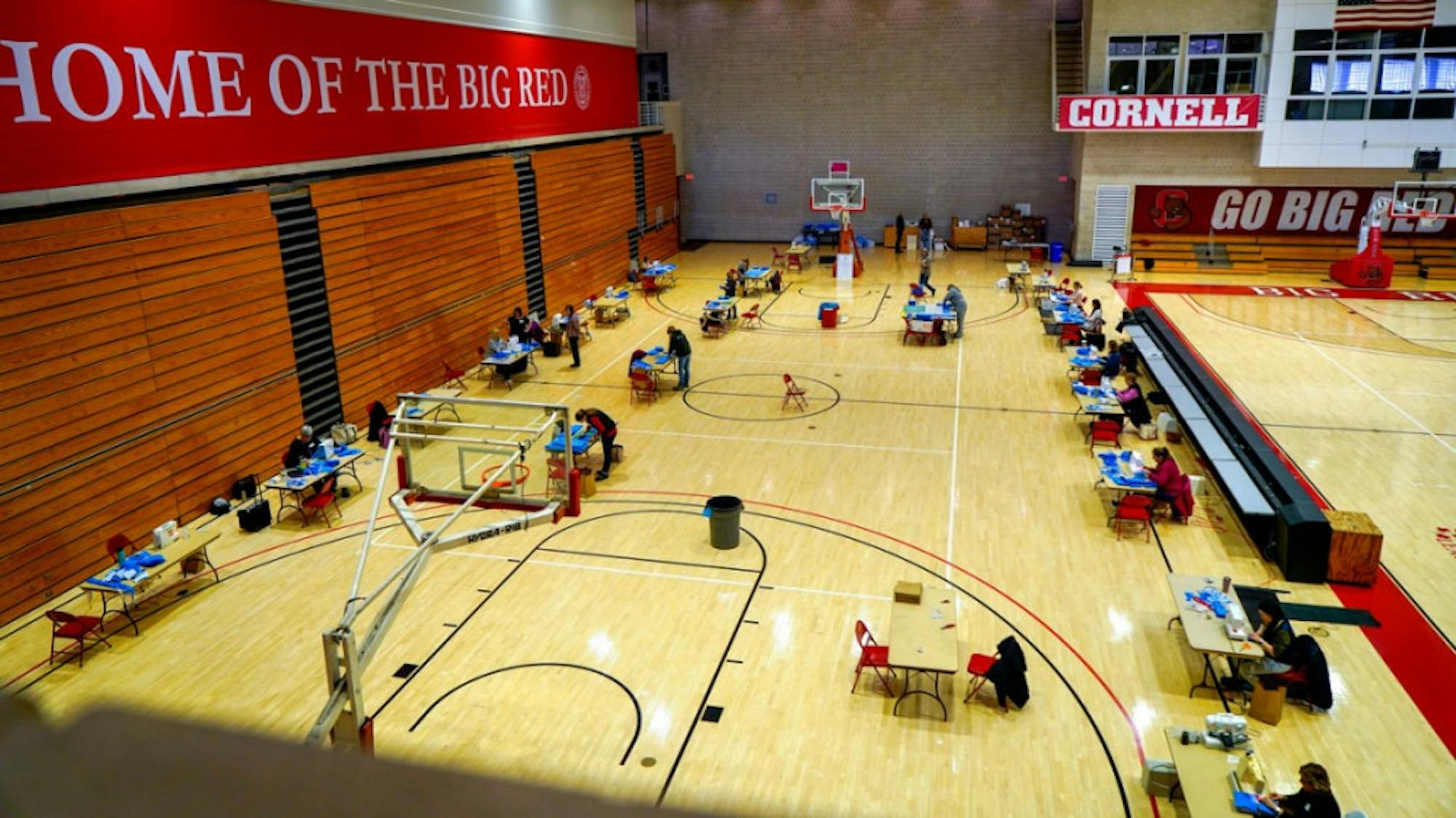 Volunteers worked at surgical mask making stations at a Bartels Hall practice court on March 25, with tables spaced to practice safe social distancing.