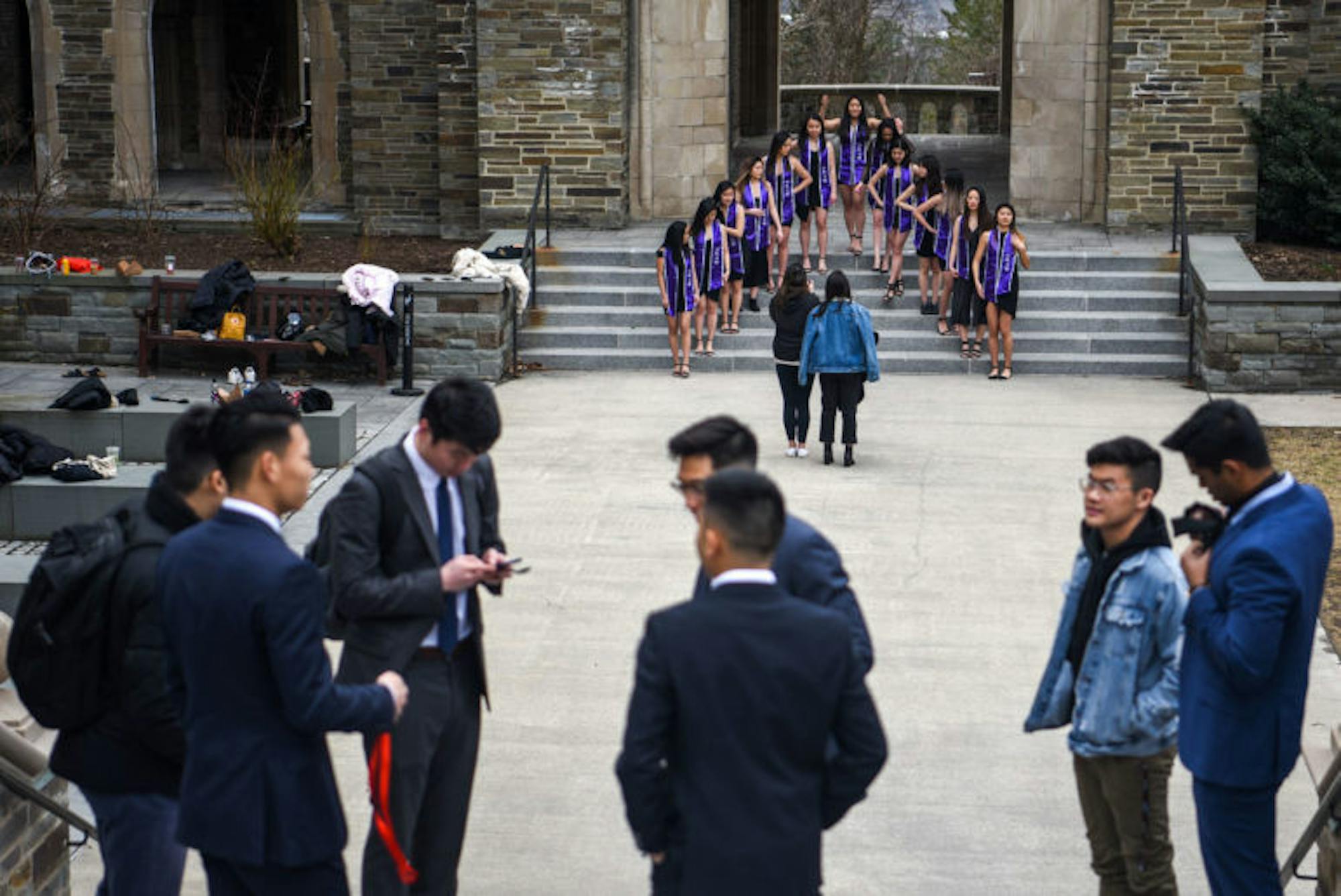 Members of alpha Kappa Delta Phi sorority posed for photos at Anabel Taylor Hall while another group waits for their picture opportunity on Wednesday.  Many seniors took advantage of the two-week class suspension to take graduation photos on campus. (Boris Tsang/Sun Photography Editor)
