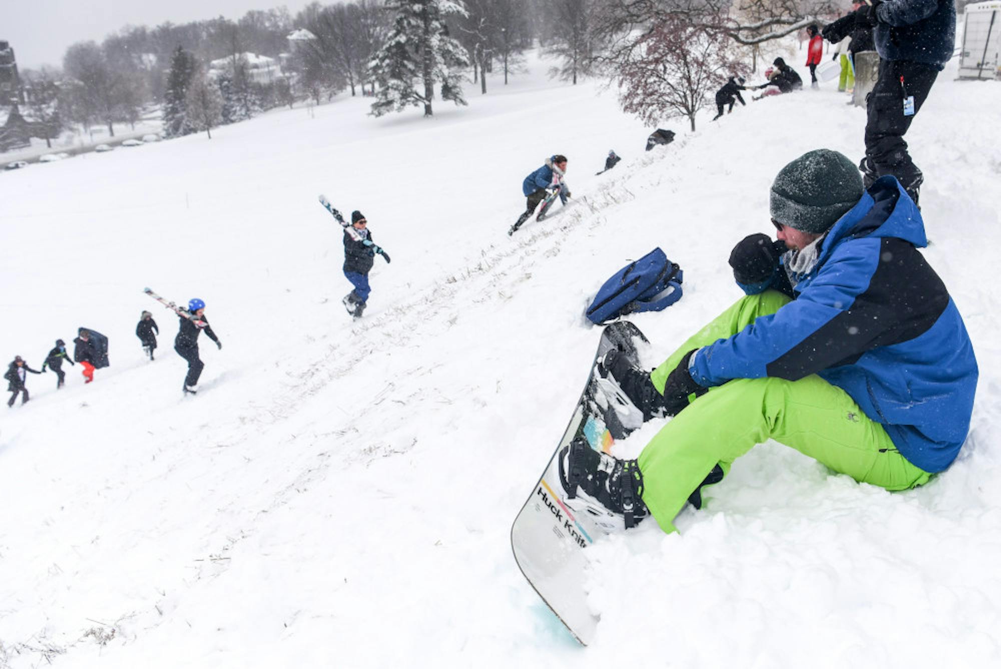 During the snow day, a student waits at the top of Libe Slope, waiting to speed down with a snowboard. Students make their way up Libe Slope after classes were cancelled and the Ithaca campus was closed on Friday. (Boris Tsang/Sun Photography Editor)