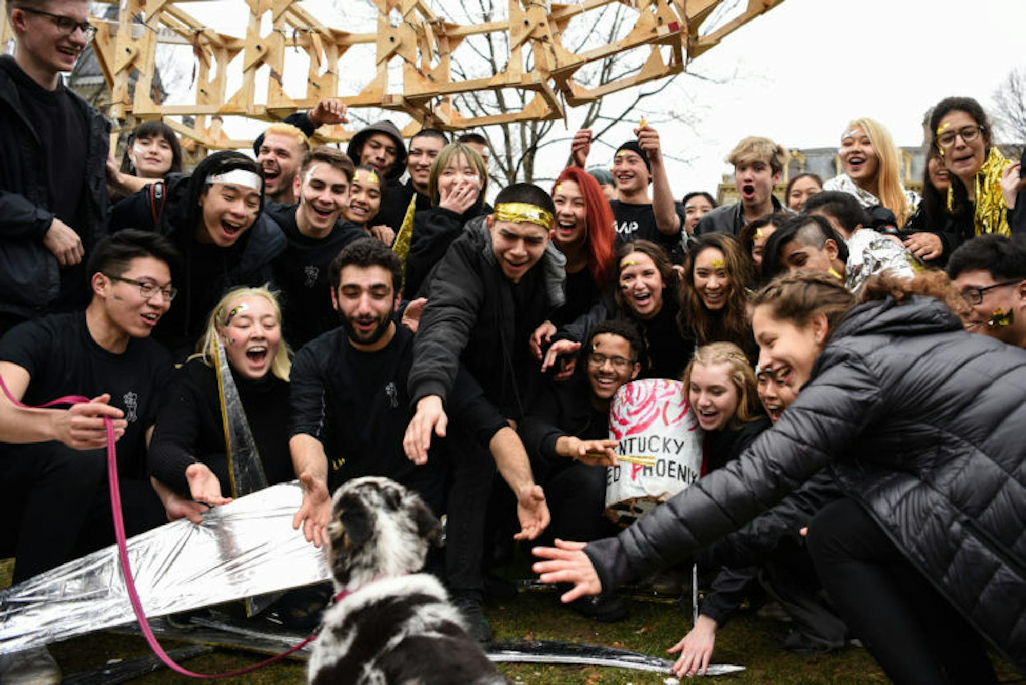 Students briefly abandon their dragon for a puppy after their group photo.