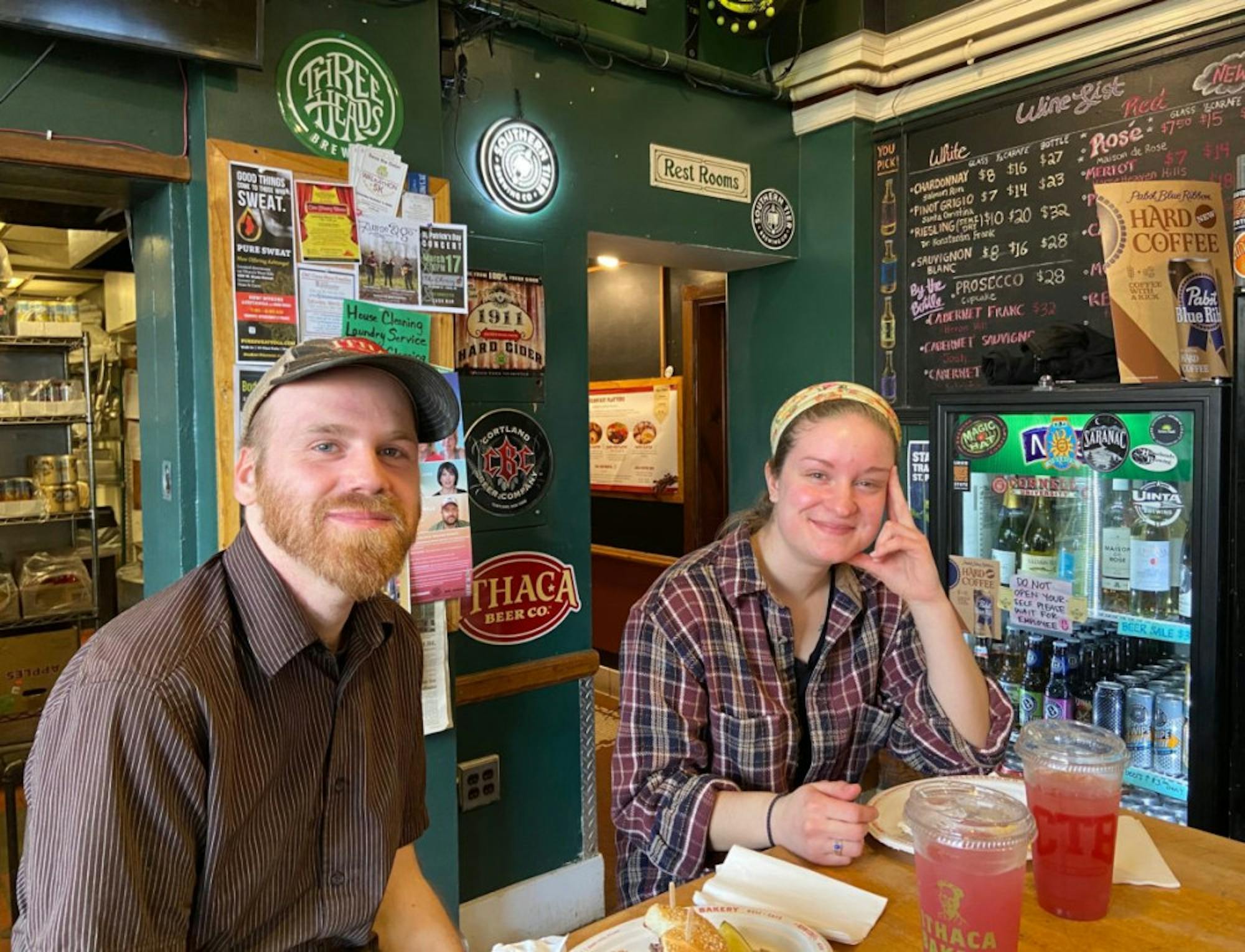 Collegetown Bagels employees Robbie Finch and Paige Twining sit in the College Ave. restaurant on Thursday. Finch said he isn't worried about the impact of Cornell's shift to online classes, but expects CTB to have summer-sized crowds during April and May.