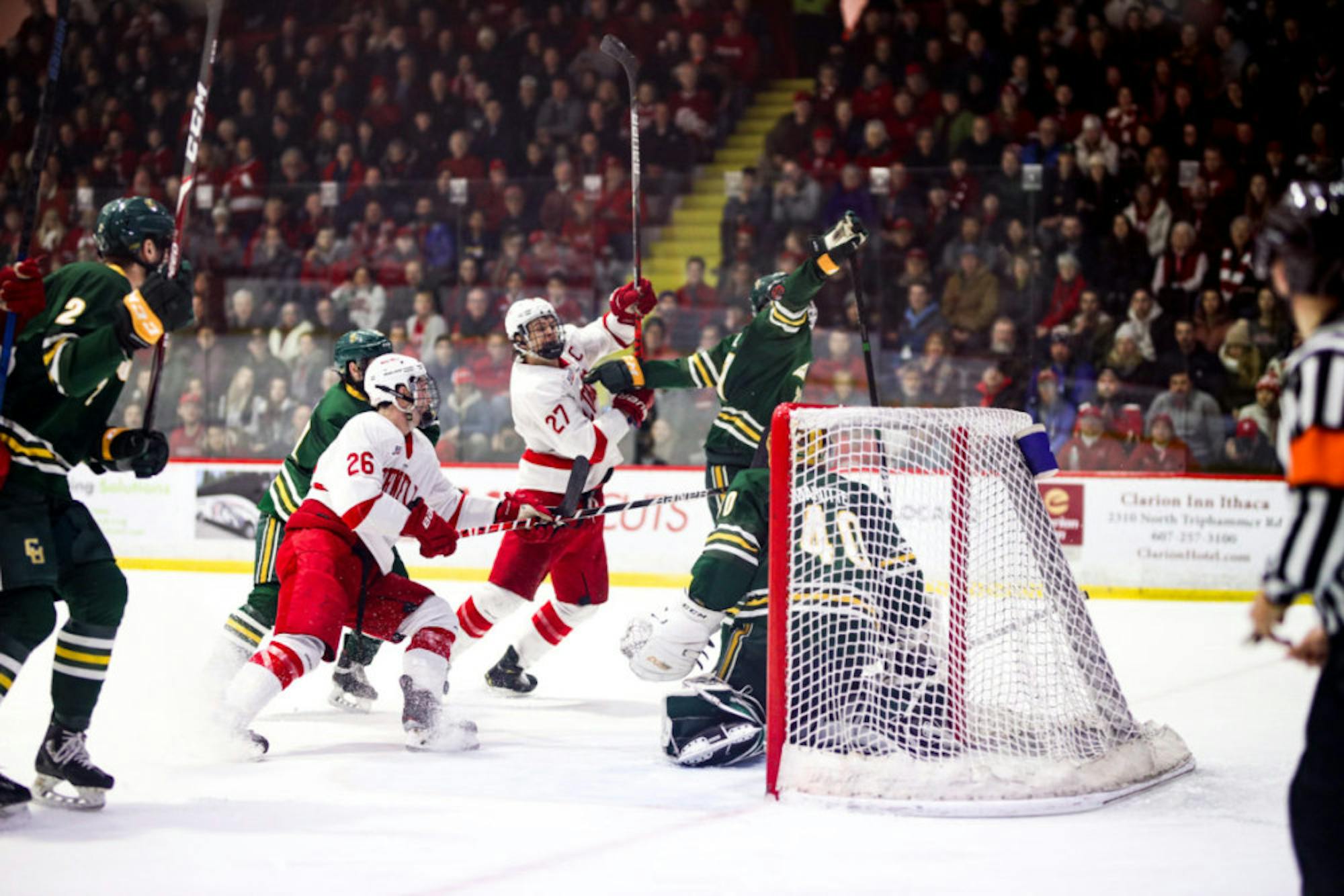Junior forward Tristan Mullin, left, and junior forward Morgan Barron, right, shoot the puck at the men's hockey game against Clarkson on Sunday. (Michael Wenye Li/Sun Senior Photographer)