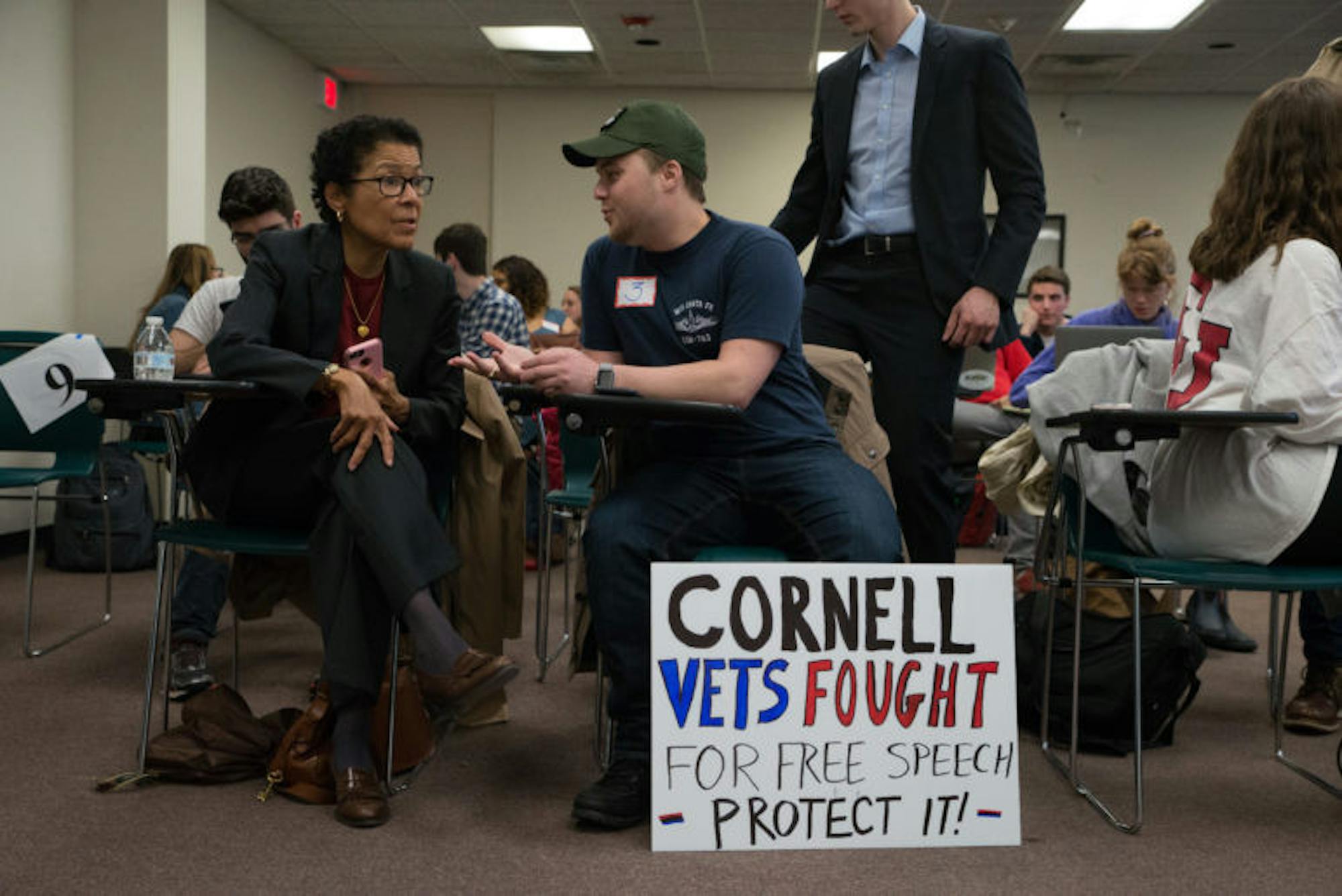 Renee Alexander '74, associate dean of students, left, converses with a student in Uris Hall, where the public hearing was streamed live.