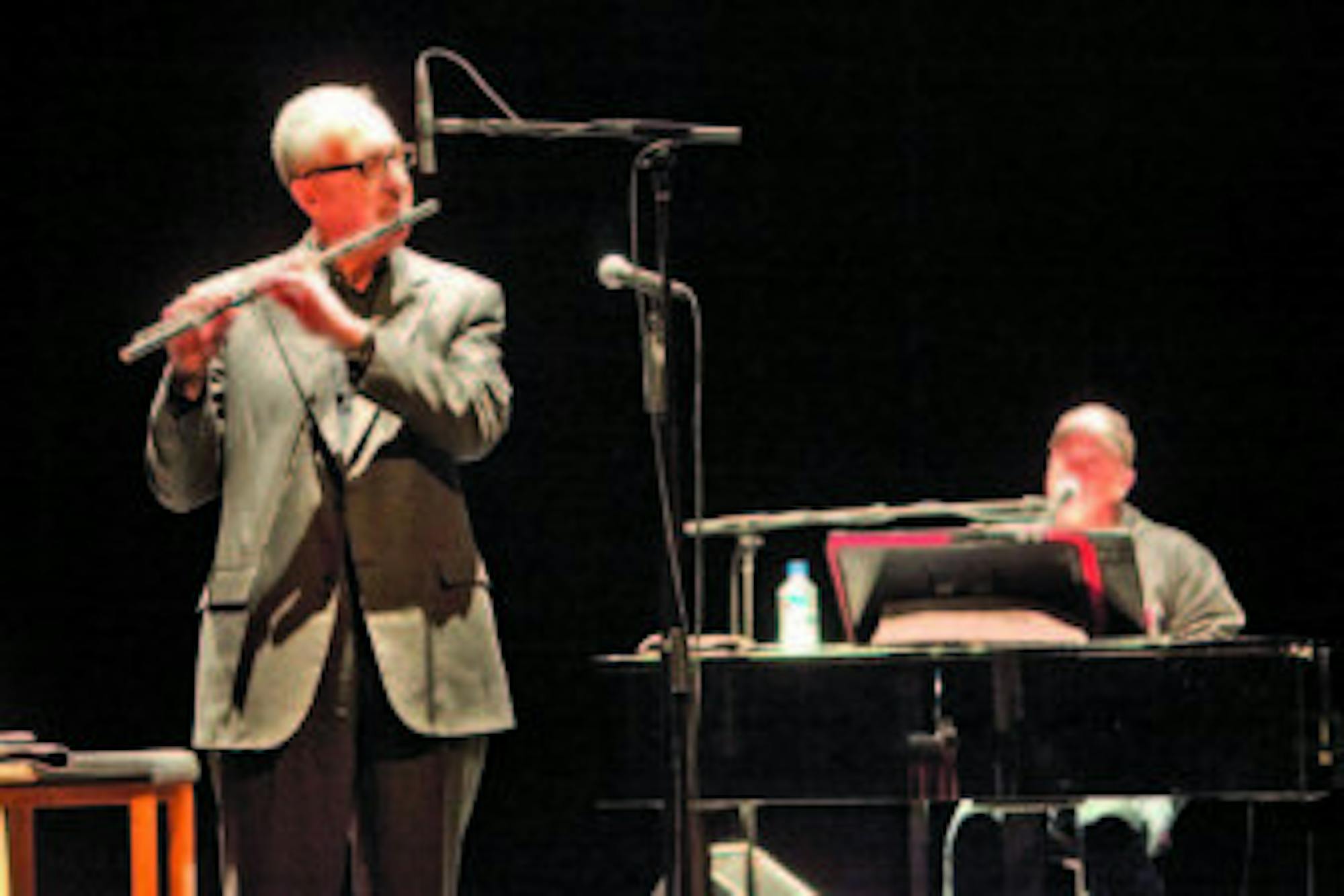 President David Skorton joins Billy Joel on stage in Barton Hall on Dec. 2, 2011 to showcase his jazz flute skills.