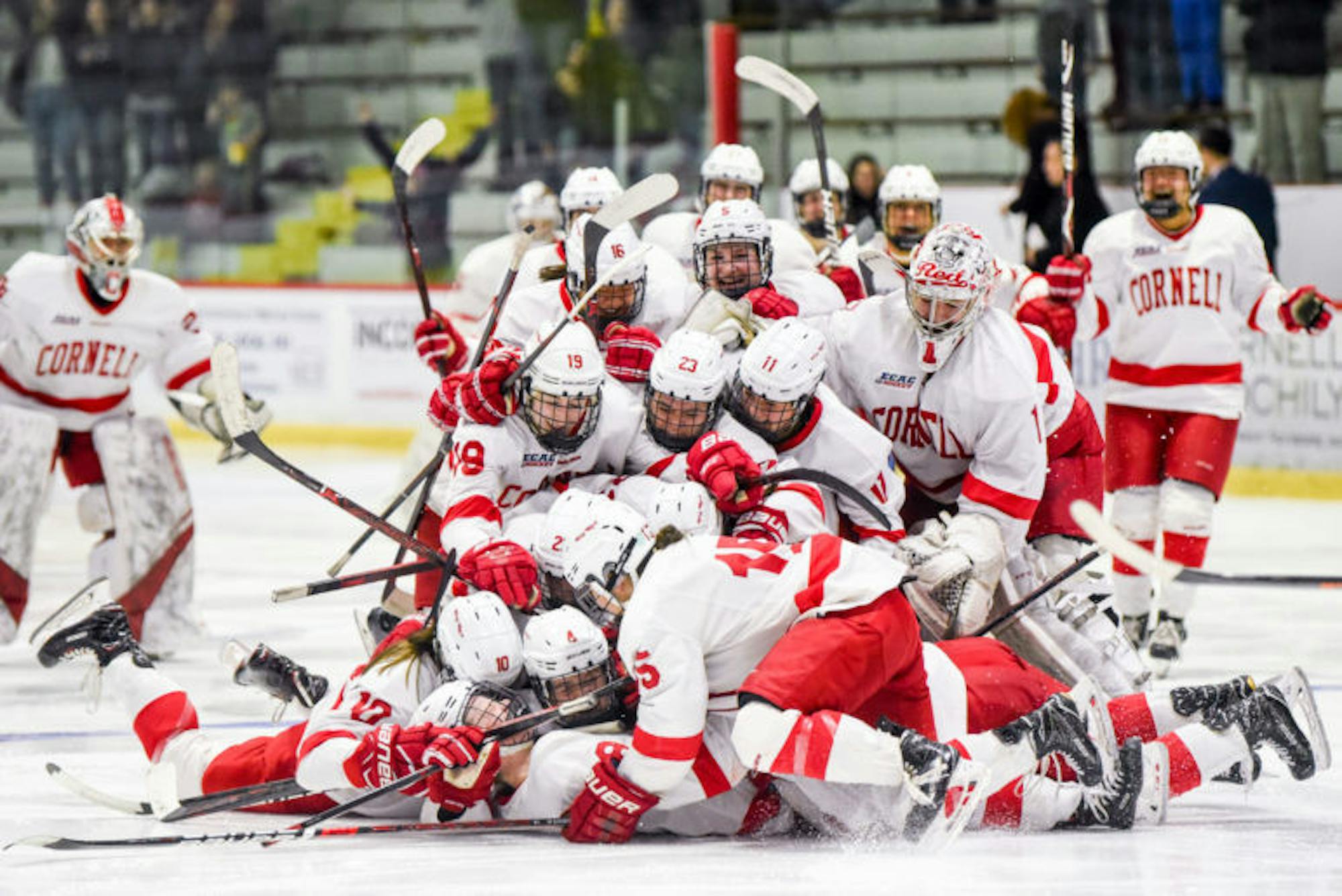 The women's hockey team piles on top of senior defenseman and captain Micah Zandee-Hart after her game-winning goal over Princeton in the second overtime period of the ECAC semifinals. (Boris Tsang / Sun Photography Editor)