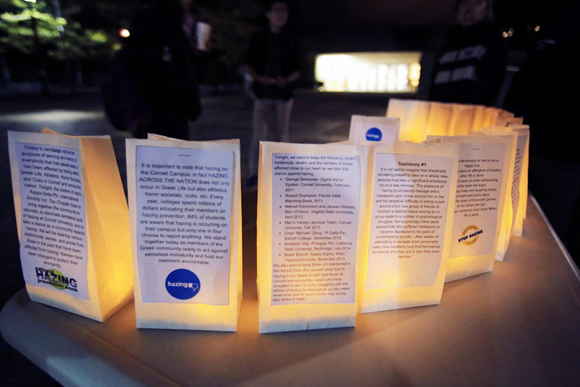 Luminaries with statements of solidarity for hazing victims are arranged in a semicircle at the alpha Kappa Delta Phi Hazing remembrance vigil on Ho Plaza. (Connor Smith / Sun Contributor)