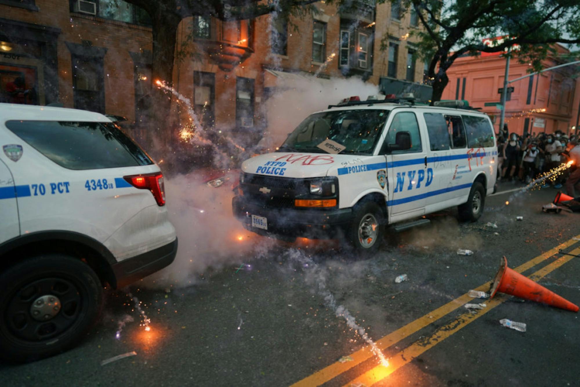 Fireworks explode around police vehicles during a protest rally in Brooklyn on May 30.