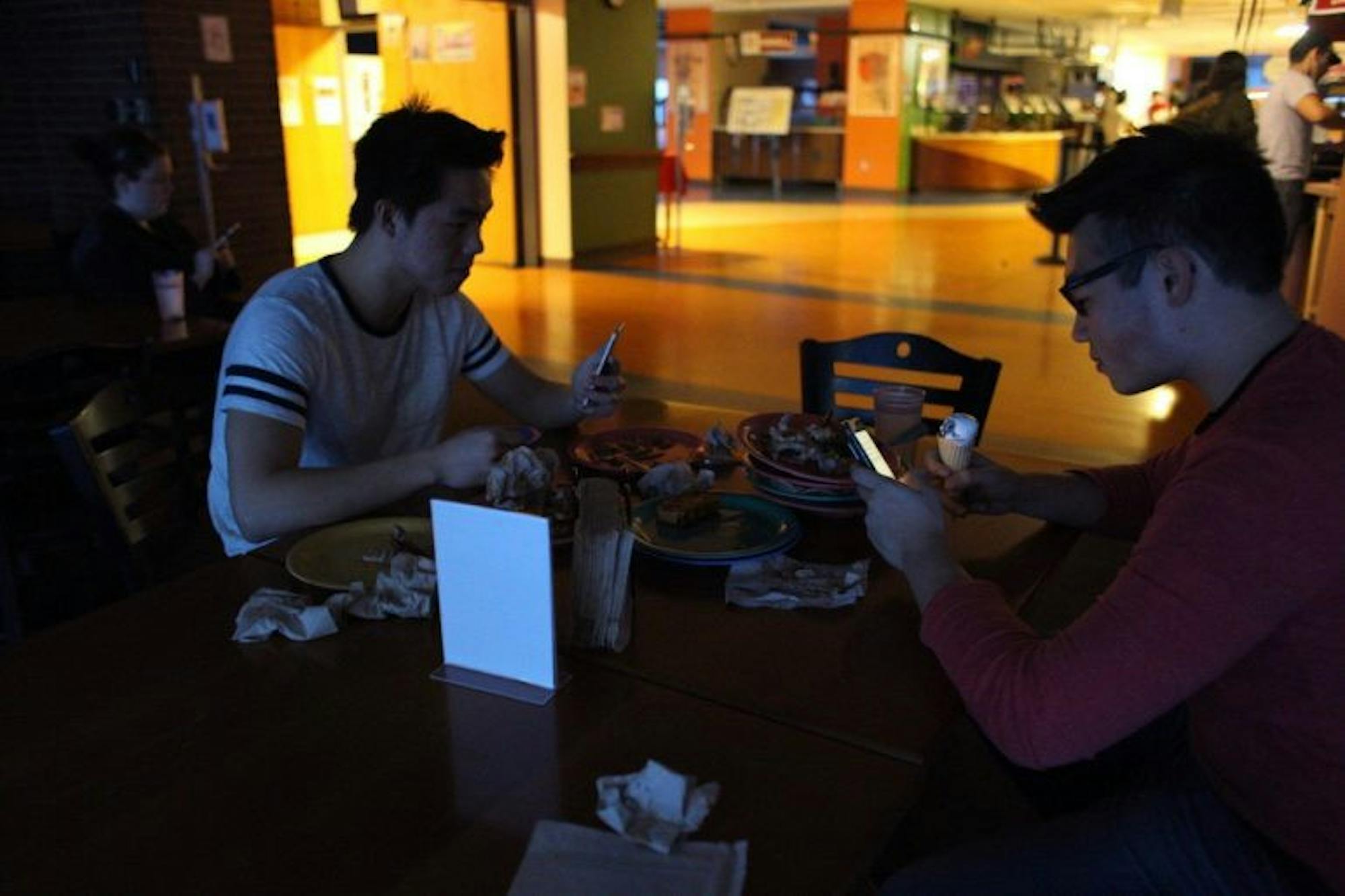 Students sit in the Robert Purcell Community Center during a power outage in Ithaca