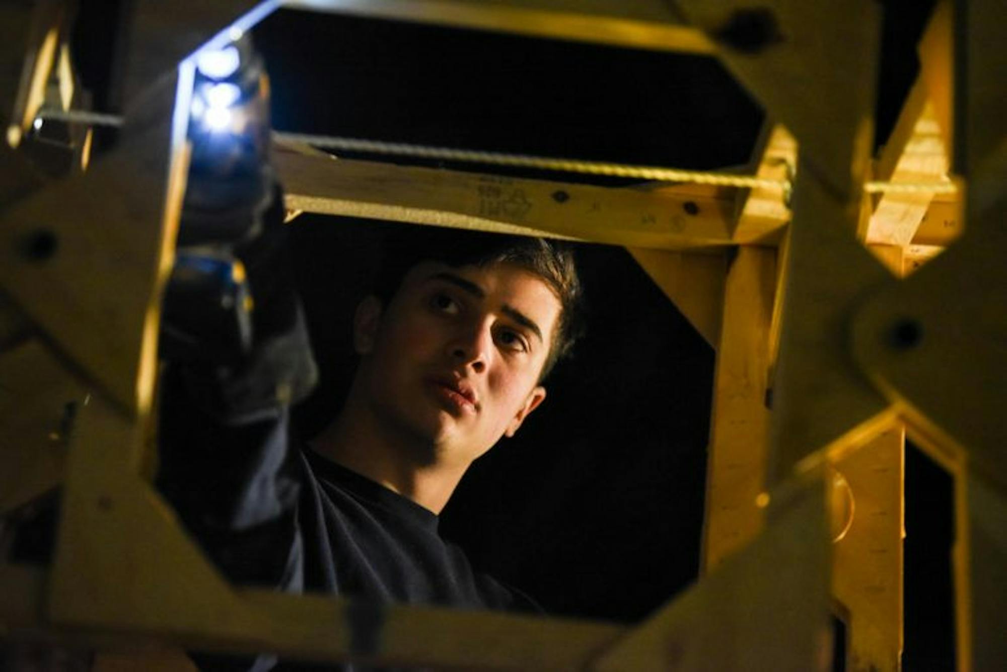 Luke Kratsios ’22 drills holes into the frame of the neck so scales can be attached. The string at the top of the frame was part of a pulley system that allowed a person to raise and lower the neck of the dragon from the inside.