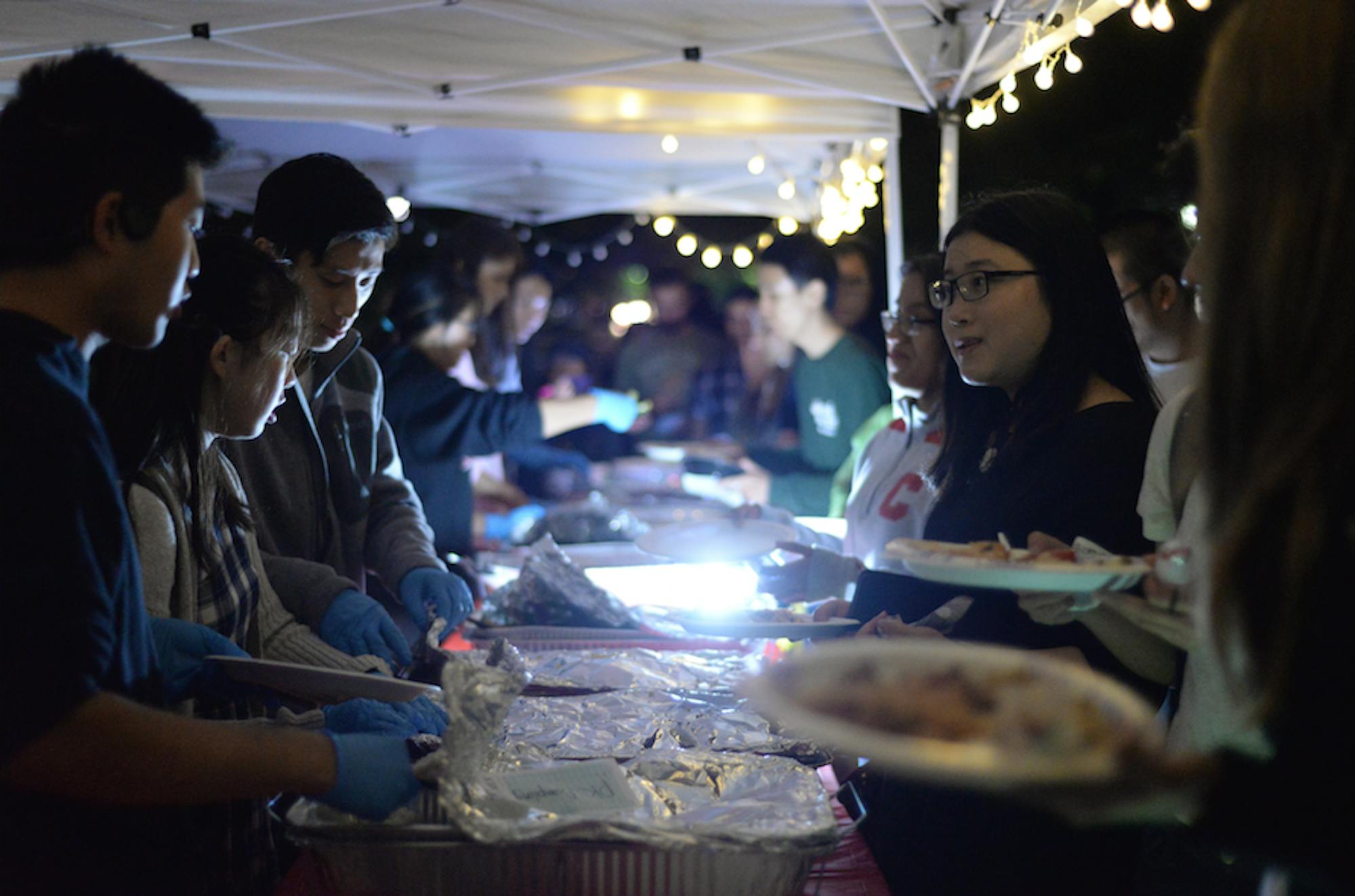 Students line up to try Asian foods in stalls on Ho Plaza Friday night.