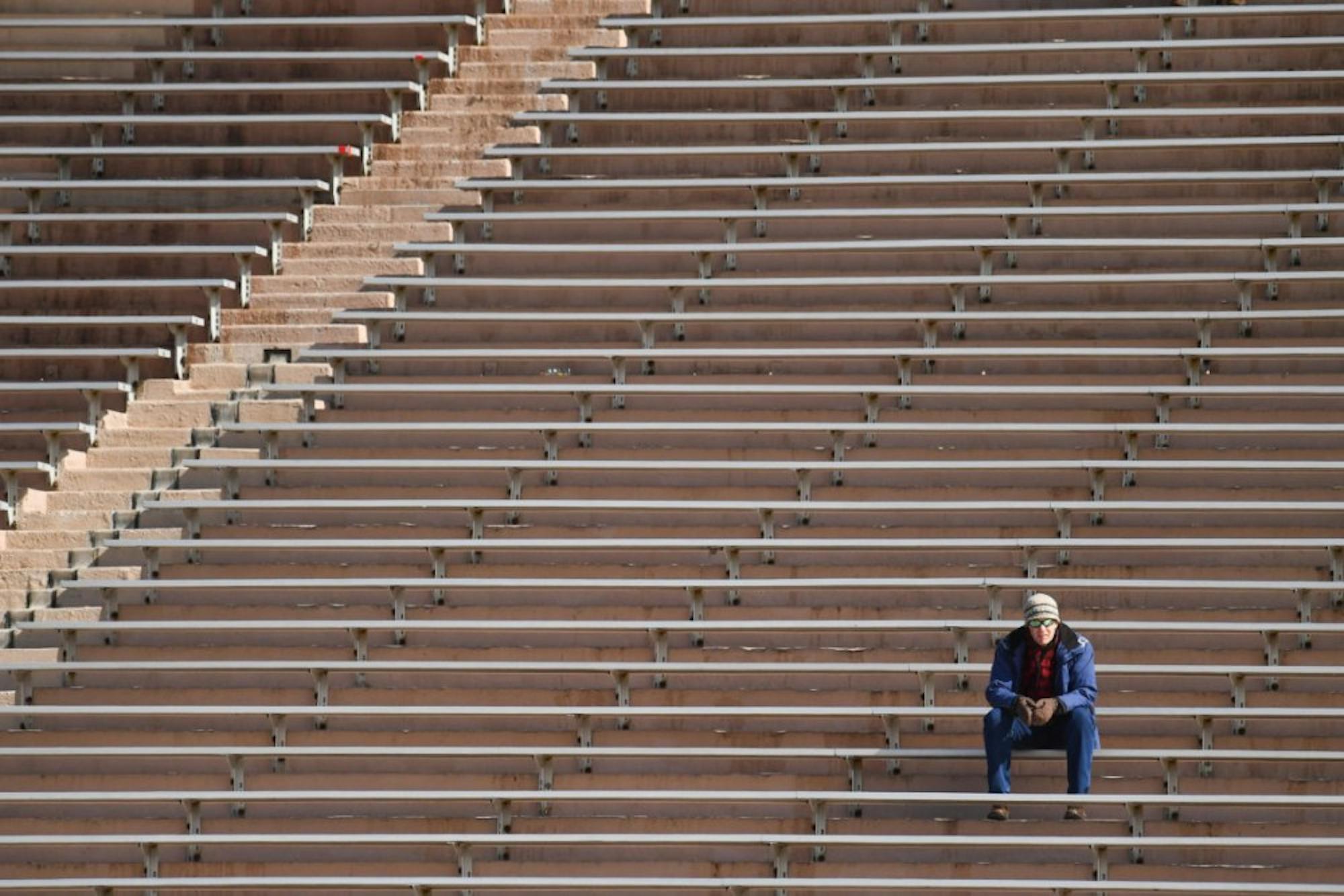 A fan watches the women's lacrosse game against Columbia on Saturday from the bleachers of Schoellkopf Field. (Ben Parker/Sun Assistant Photography Editor)