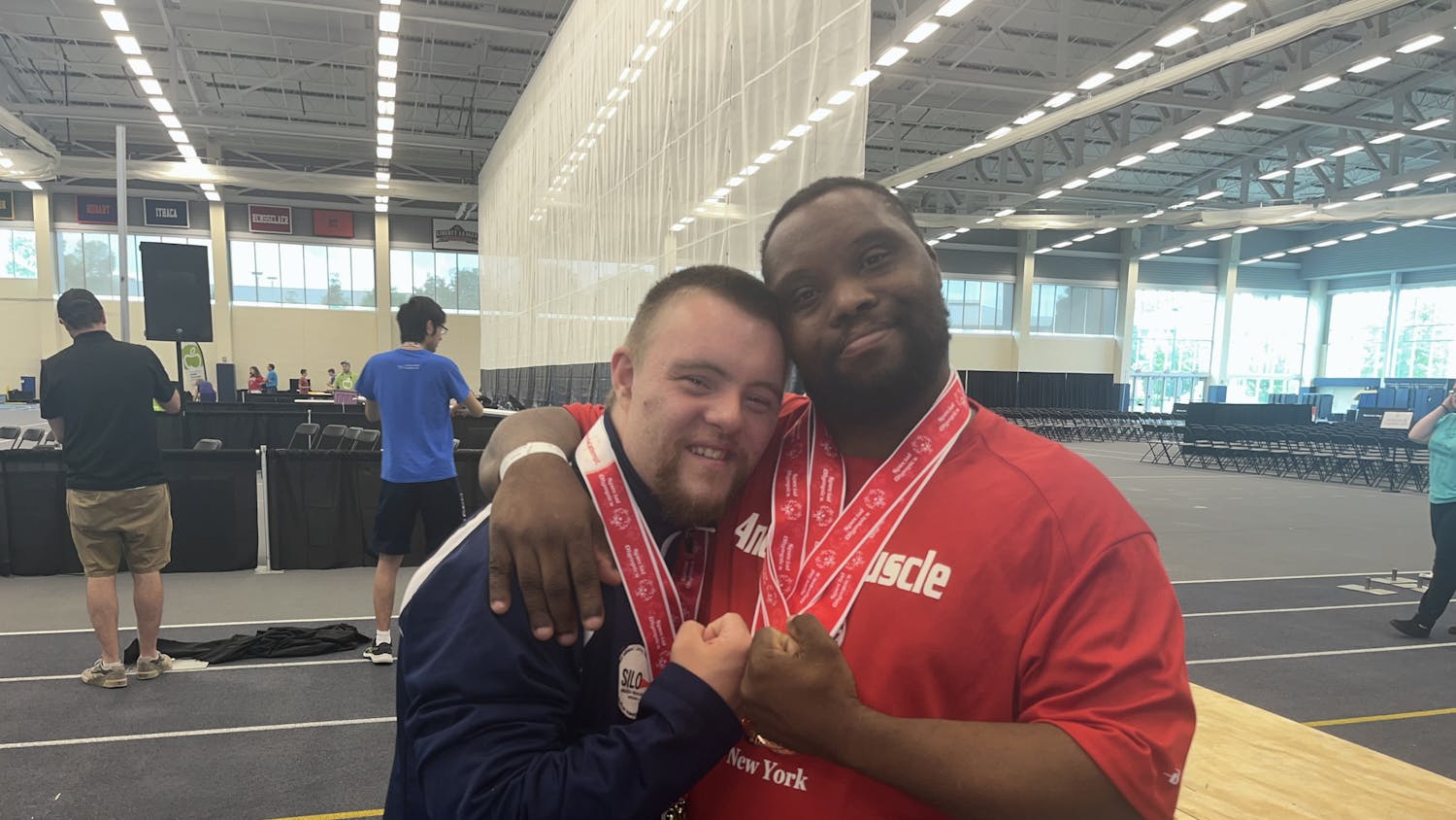 Joey Collins (left) and Daniel Fletcher (right) hug after receiving their medals for powerlifting.