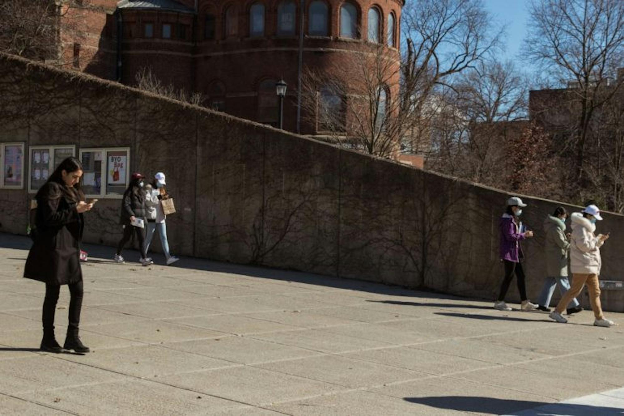 Students wear masks while reading President Pollack's latest update on the fate of the semester and in-person classes on Friday. (Hannah Rosenberg/Sun Assistant Photography Editor)
