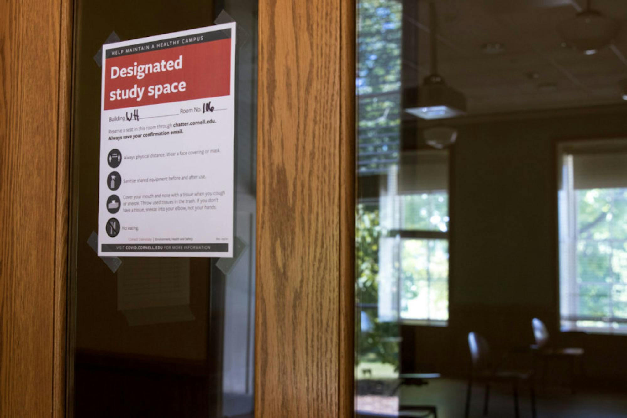 Signs adorn doors to study spaces around campus, advising social distancing procedures and occupancy limits.