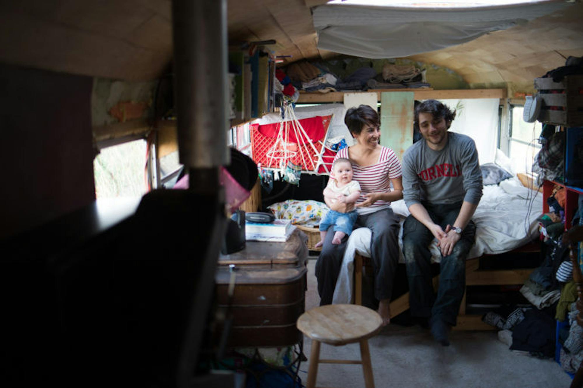 Eli Shanks '17 poses with his partner Andrea Reyes and his son Rafael in their school bus-turned-home in Trumansburg, New York, September 17th, 2017. (Cameron Pollack / Sun Photography Editor)