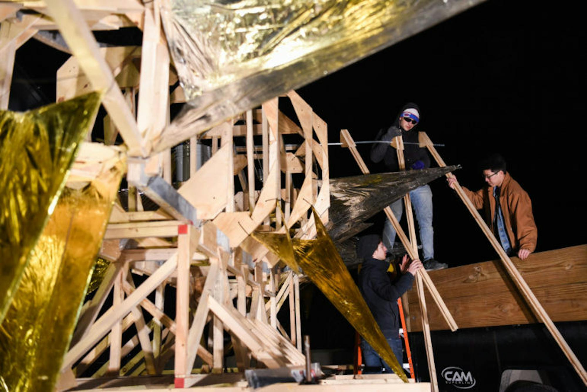 Students test out parts of the right wing. The final design involved a pair of movable wings, but they were dropped in the final minutes before the parade after the connection point with the frame broke.