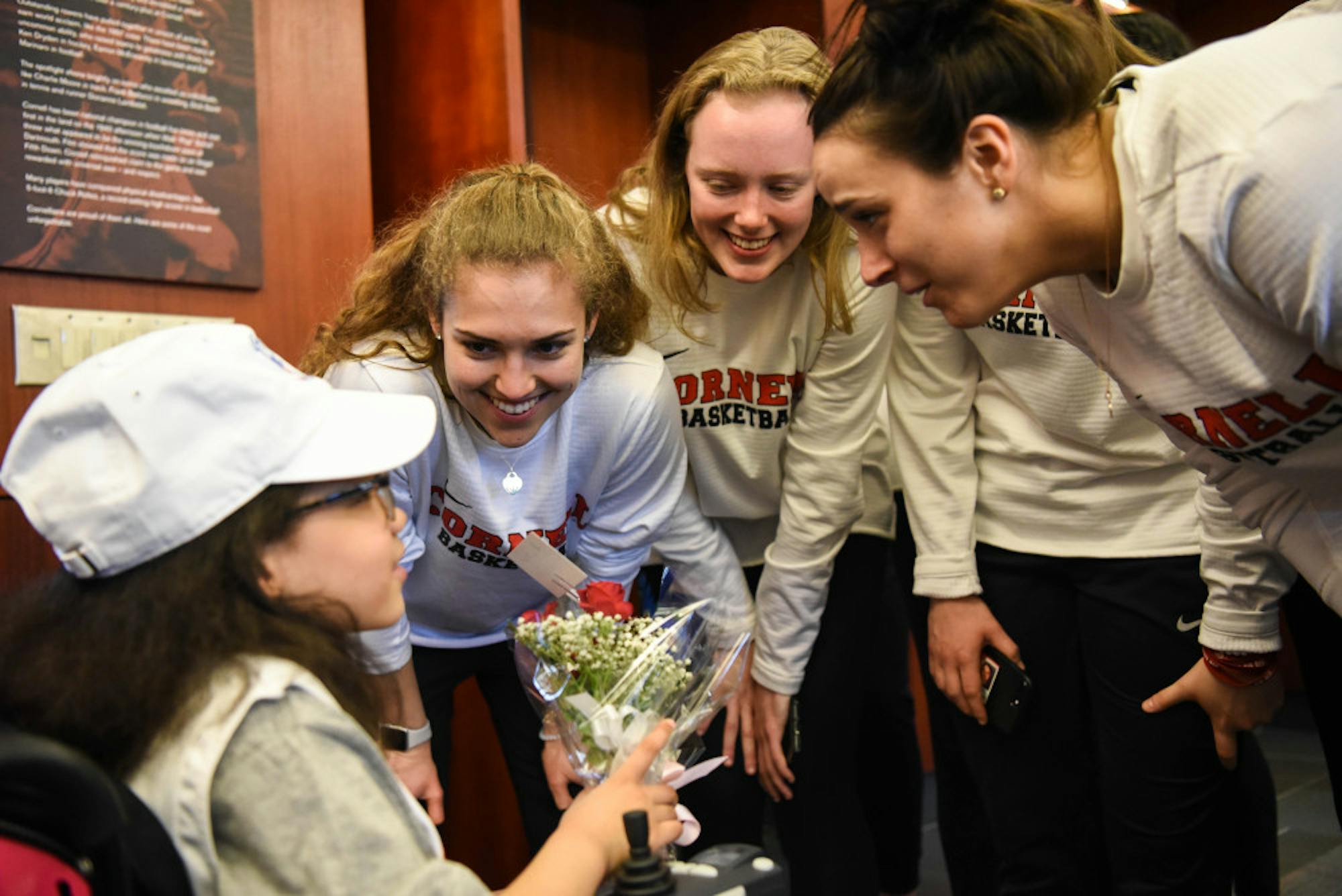 Members of the Cornell women's basketball teams congratulate 7 year-old Karina Hill after she signed her