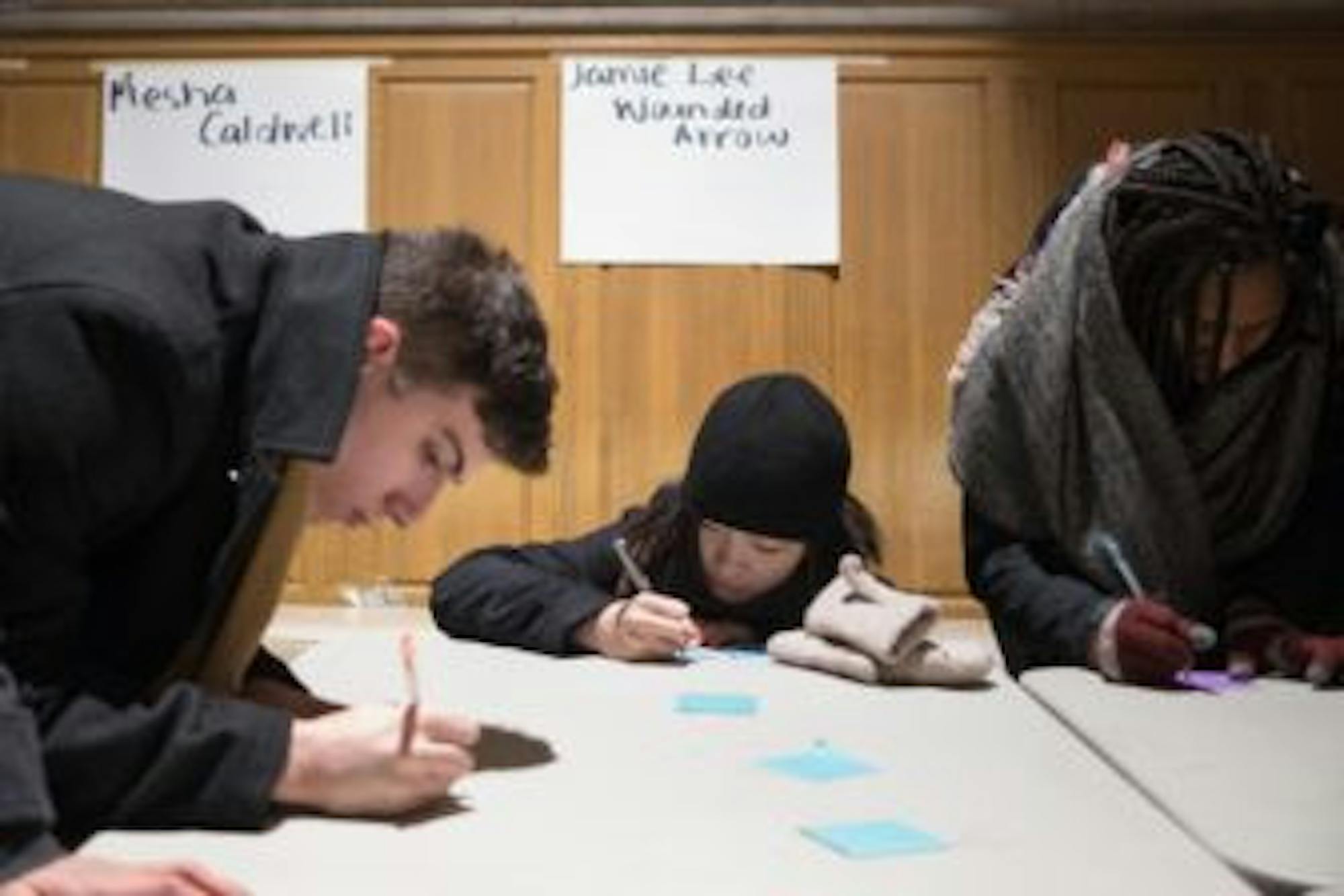 Demonstrators writing messages for victims at the Vigil for Transwomxn at Willar Straight Hall on Wednesday.