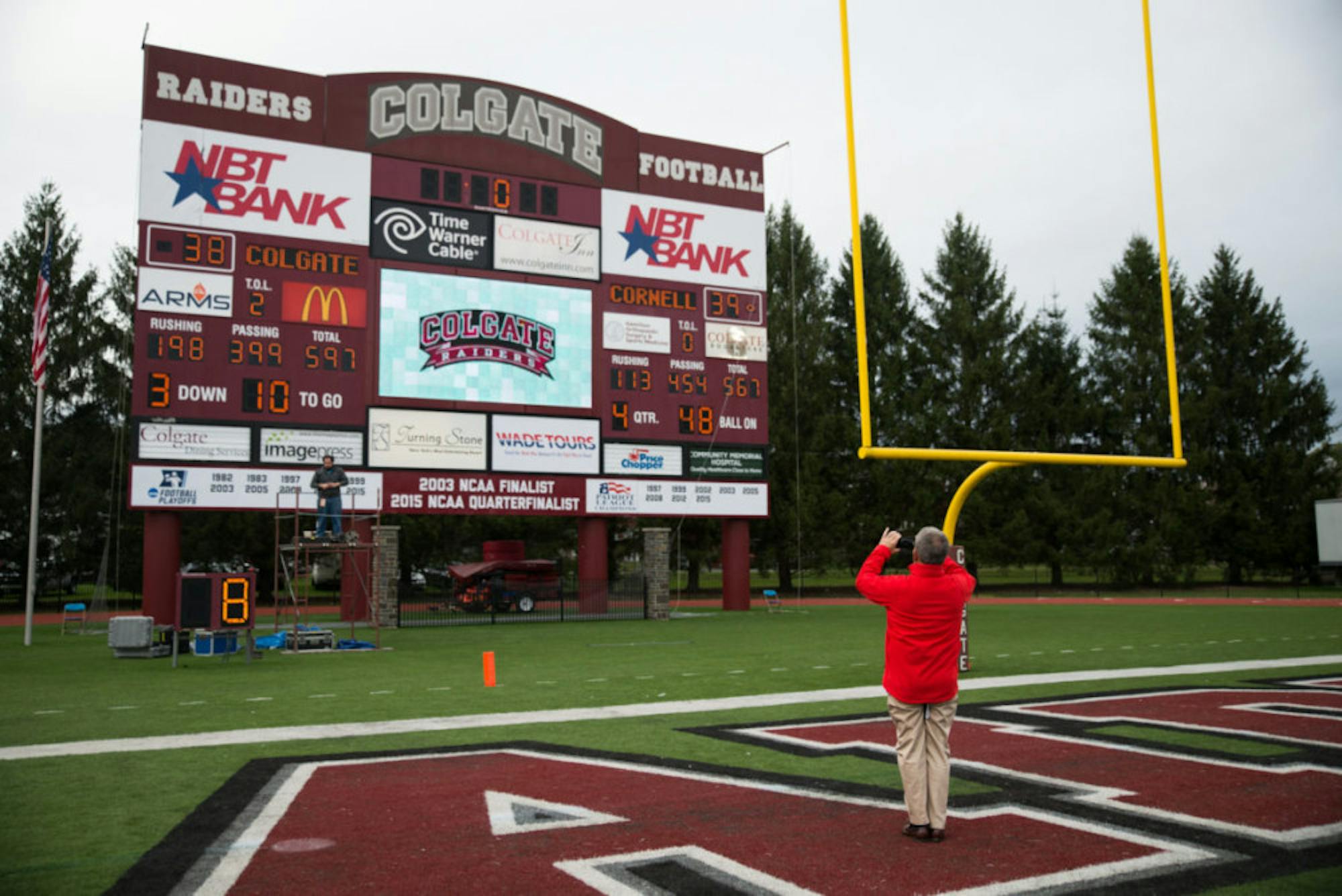 Athletic Director Andy Noel captures a moment in history with the scoreboard from the win over Colgate. Saturday will be the 100th meeting between Cornell and Colgate.