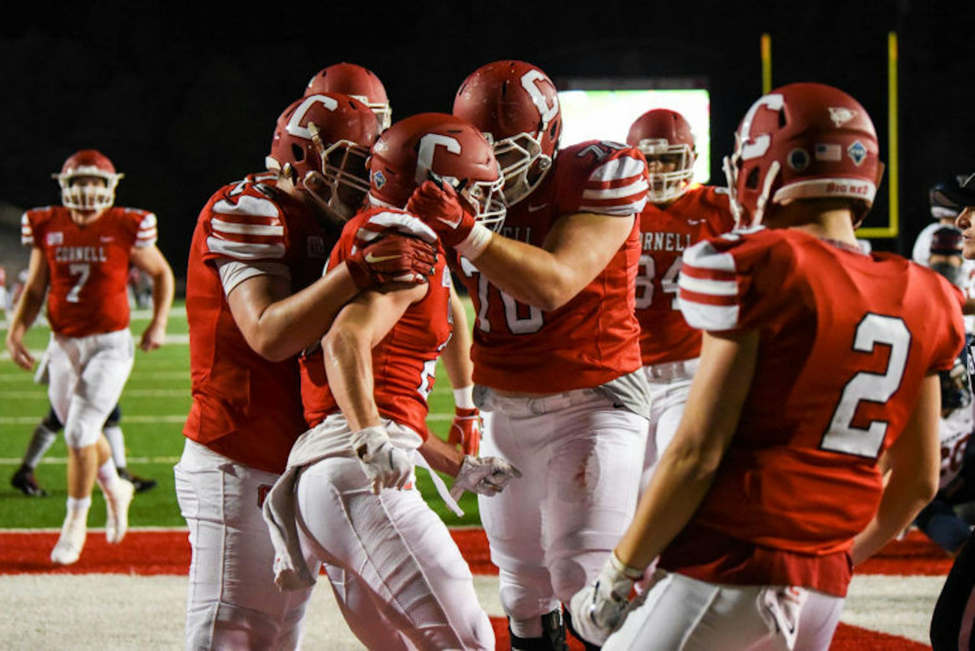 Senior wide receiver Lars Pedersen is surrounded by teammates after scoring the first touchdown of the game against Penn on Friday night. Although the Red entered halftime with a 7-3 lead, the Quakers ultimately claimed the victory with a dominant performance in the second half. (Boris Tsang / Sun Assistant Photography Editor)