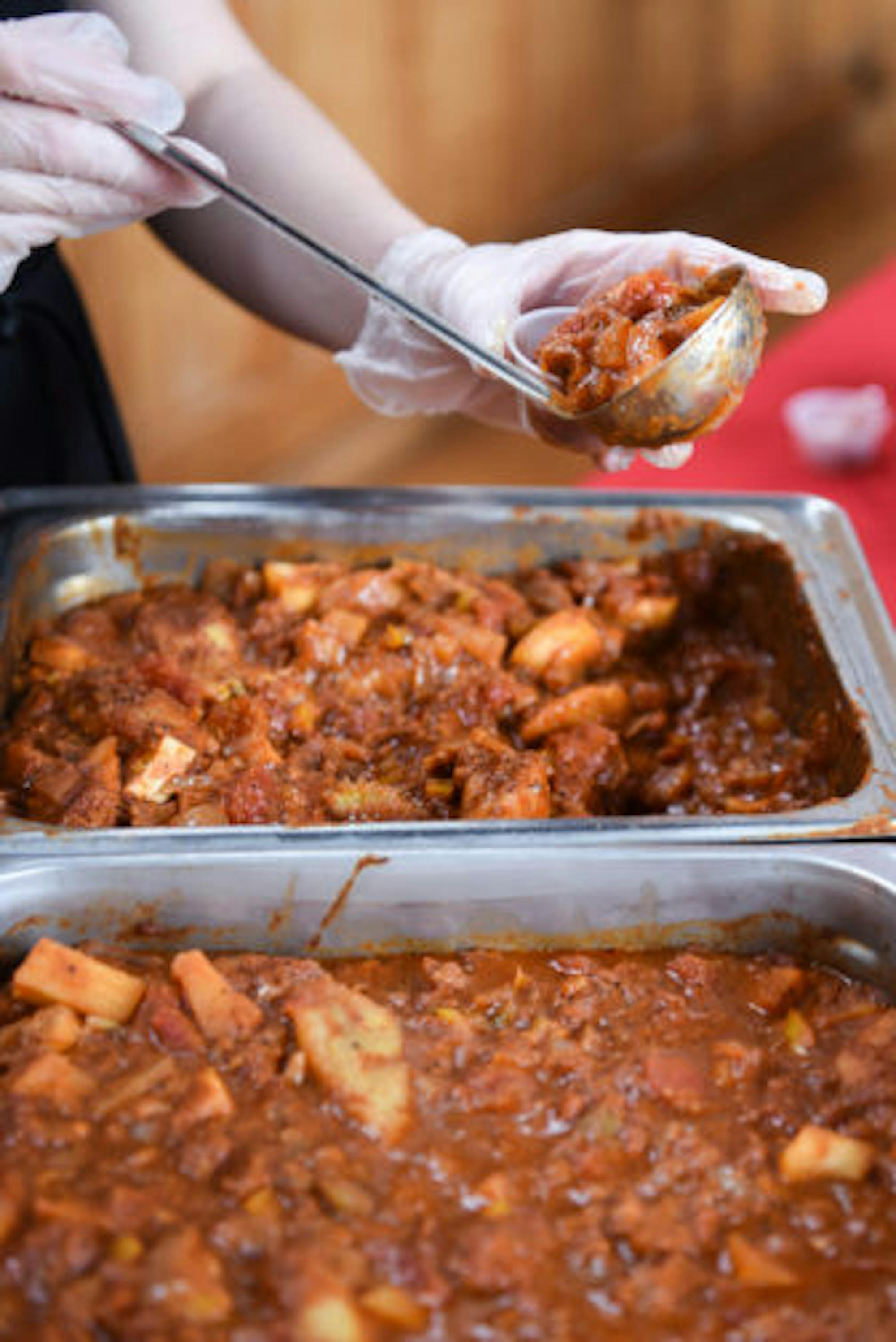 A volunteer scoops chili at the cook-off.
