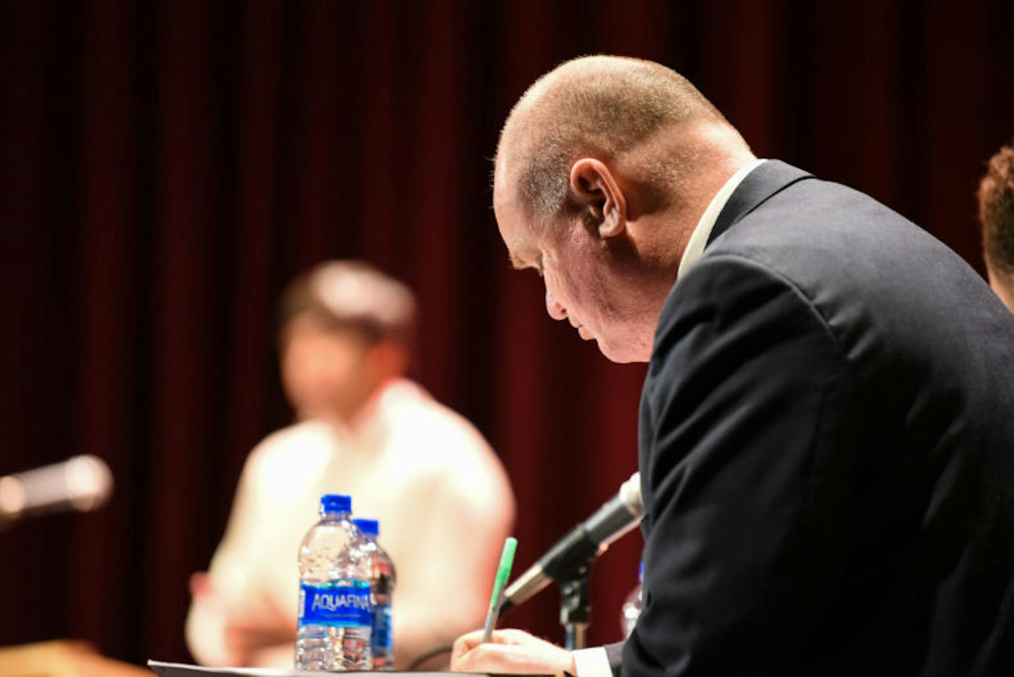 Prof. Sam Nelson, labor relations, law and history and director of the Cornell Speech and Debate Society, takes notes during the debate between Cornell and Harvard at the State Theatre on Thursday night.