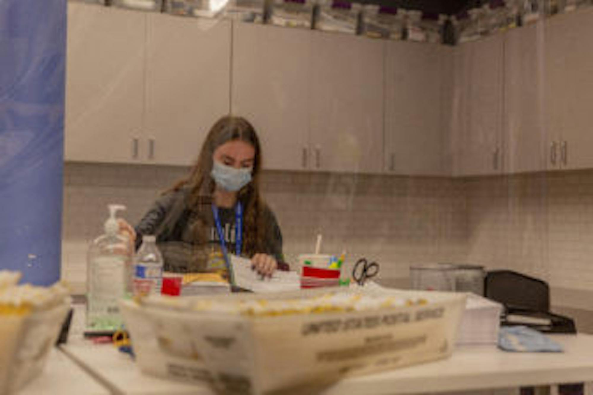 Kayla Tuttle, 18, sorts through ballots to be mailed to voters in West Bloomfield Township, Mich., Sept. 24, 2020. With many traditional polling site volunteers reluctant to spend hours in direct contact with large groups, thousands of high school students and other young people are stepping forward.
