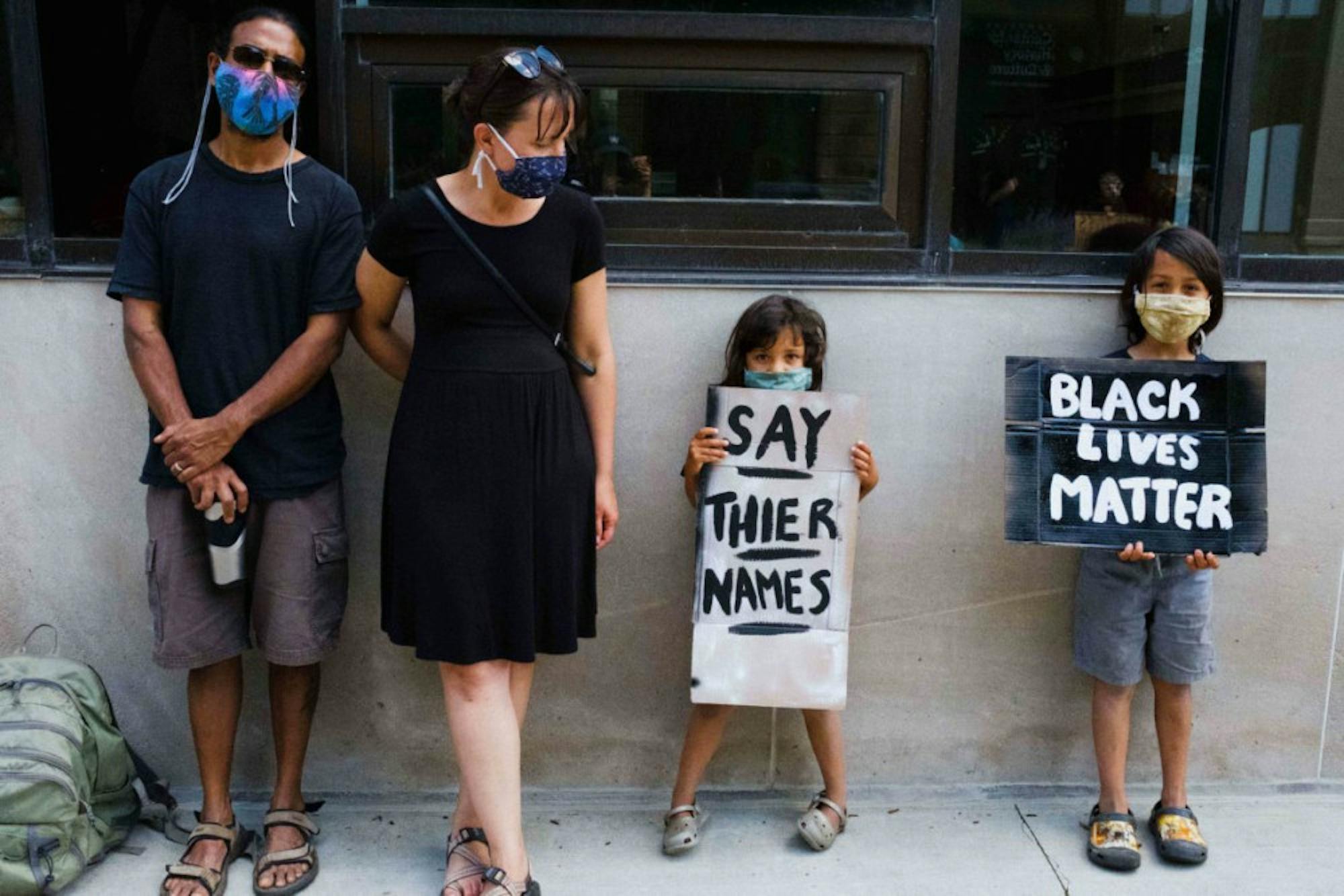 Young children hold signs, denouncing the deaths of Black people caused by police brutality. (Michael Suguitan / Sun Staff Photographer).