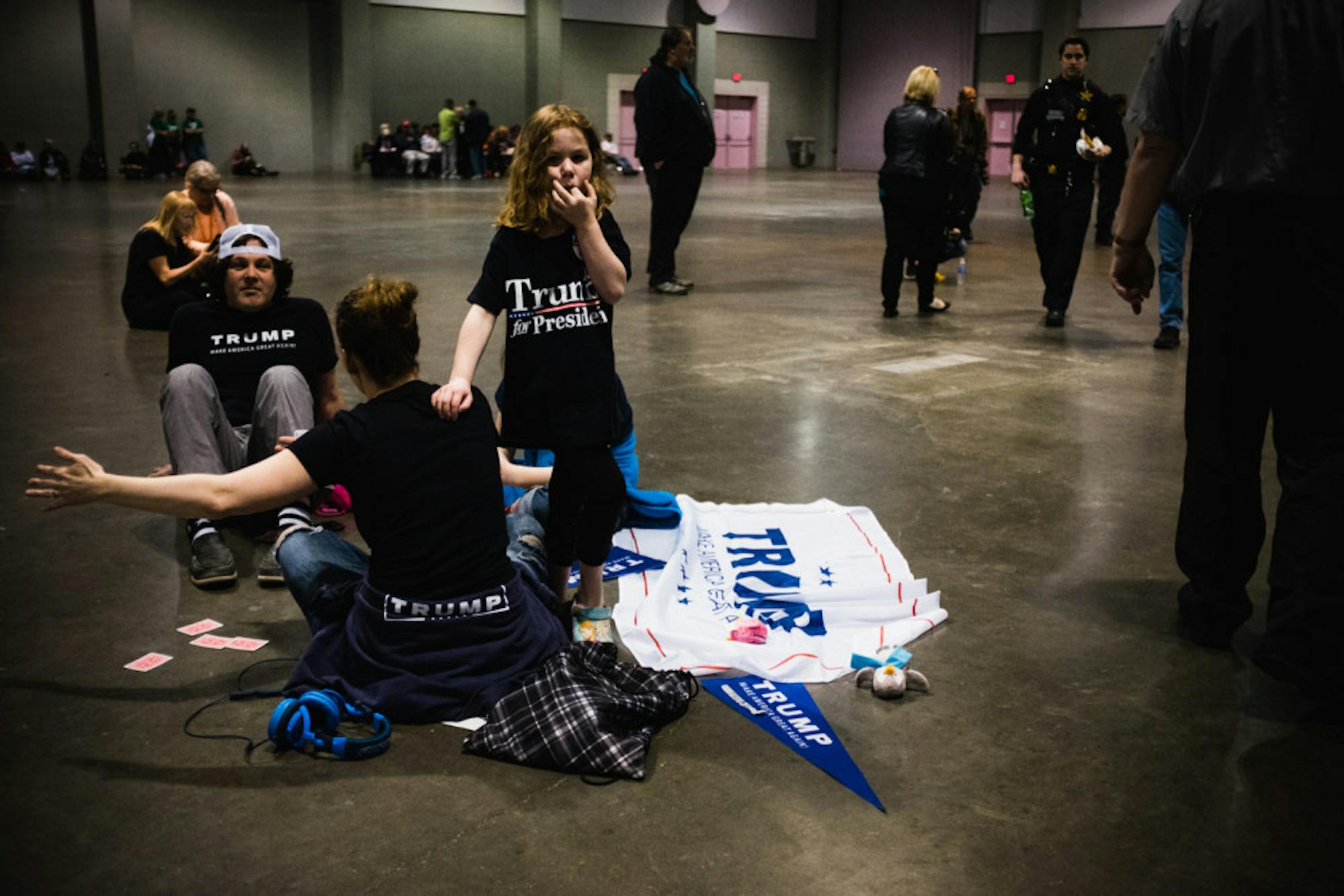 A family of Trump supporters sits on the group before the candidate's rally Saturday.