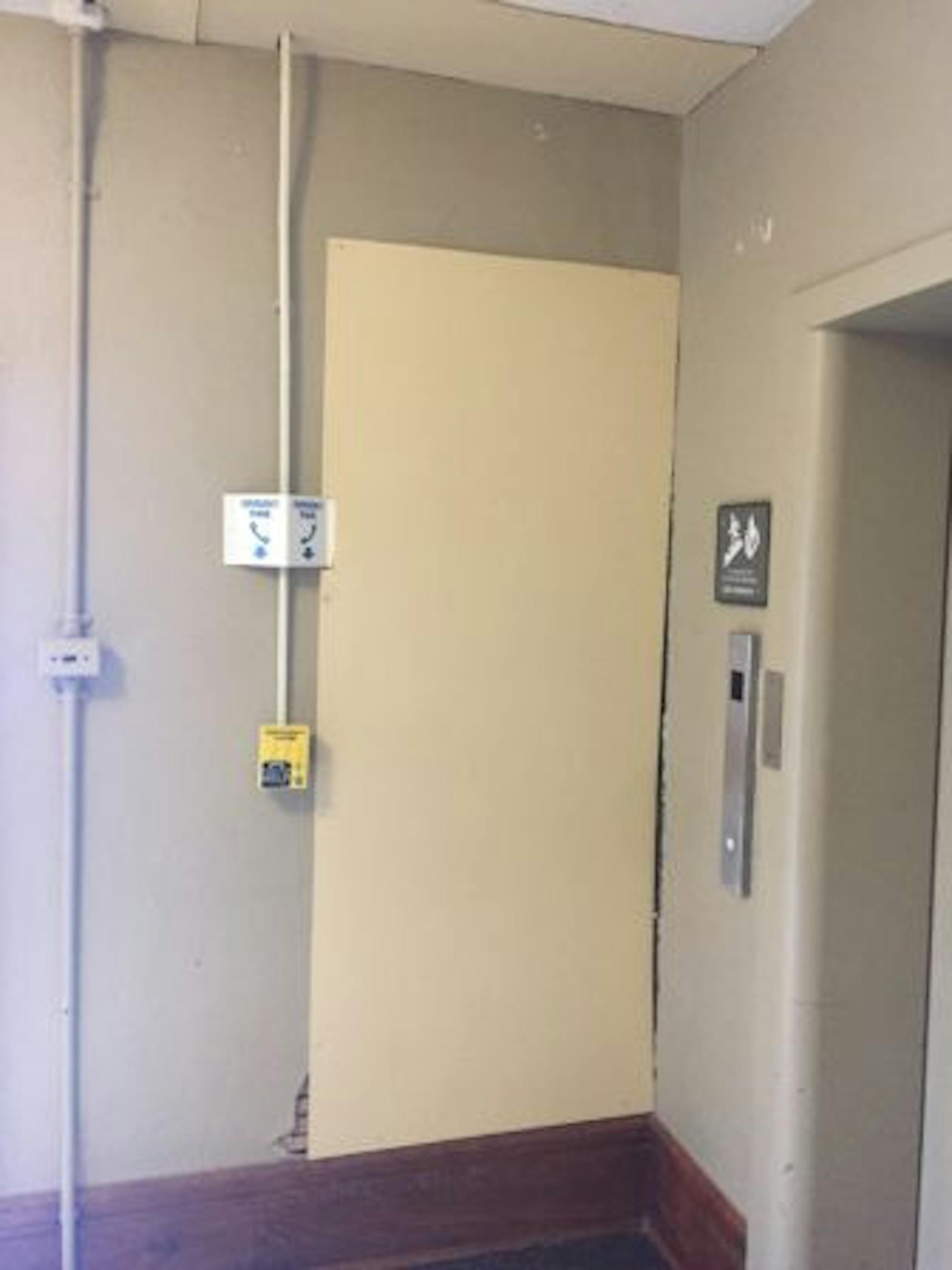 Exposed wall in McGraw Hall elevator hall covered by a thin panel.