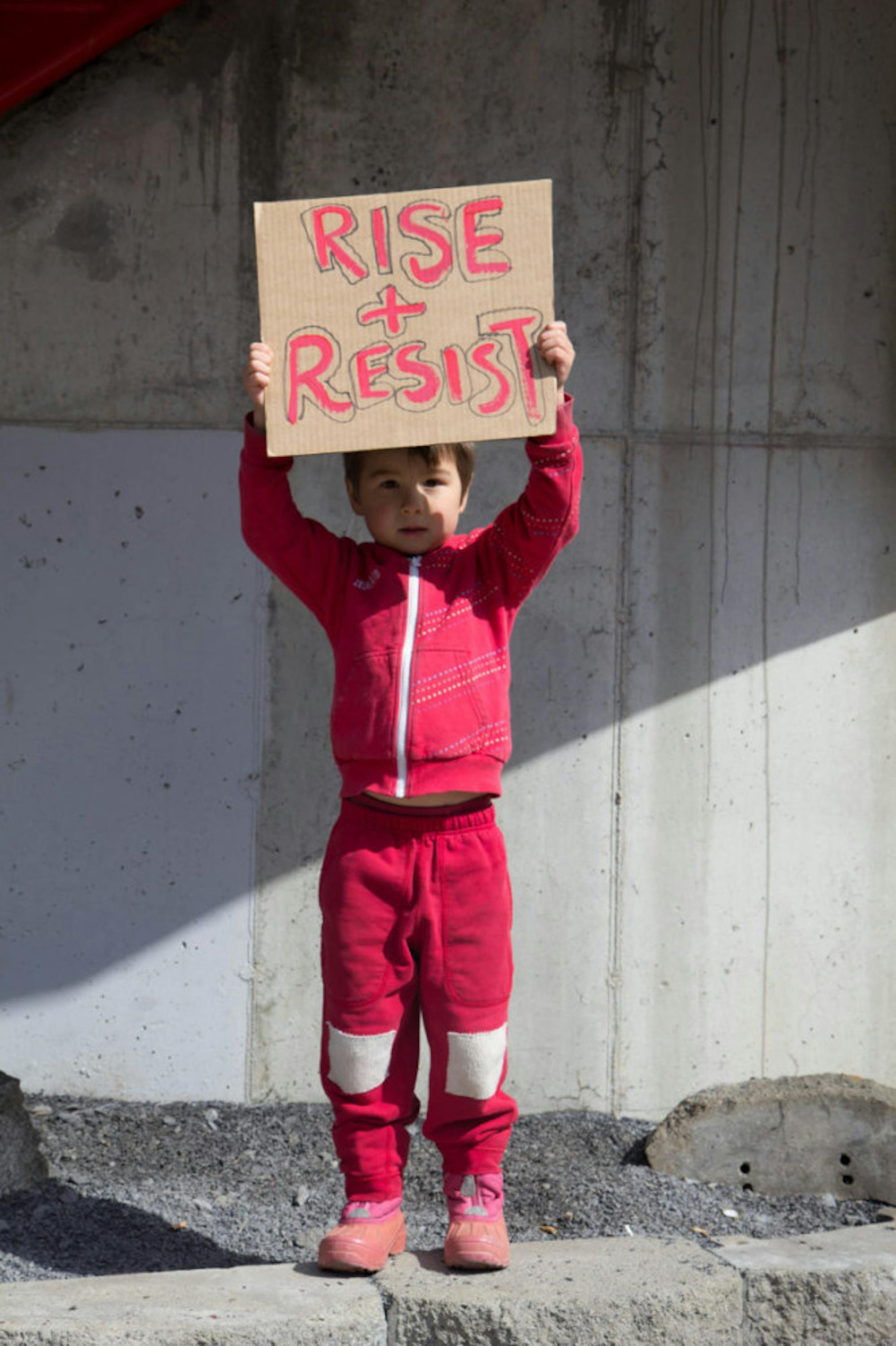One of many children donning red at the Women's March on Wednesday, Leo holds a sign outside of City Hall.