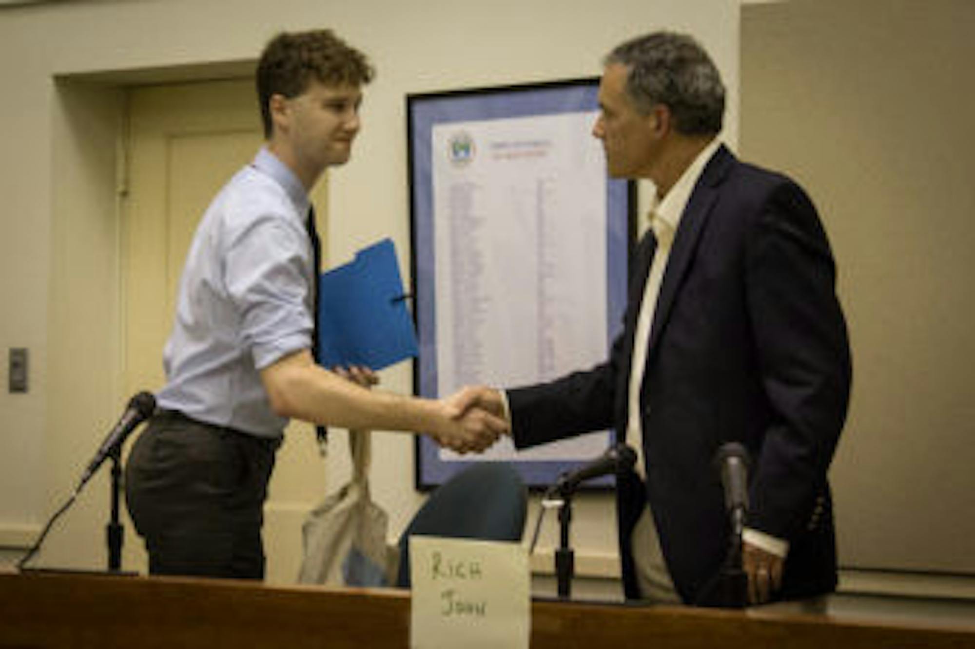 Reed Steberger '13, left, and Rich John '81 shake hands on Thursday after Steberger withdrew from the race, leaving John, the incumbent, to run uncontested for the District Four seat.
