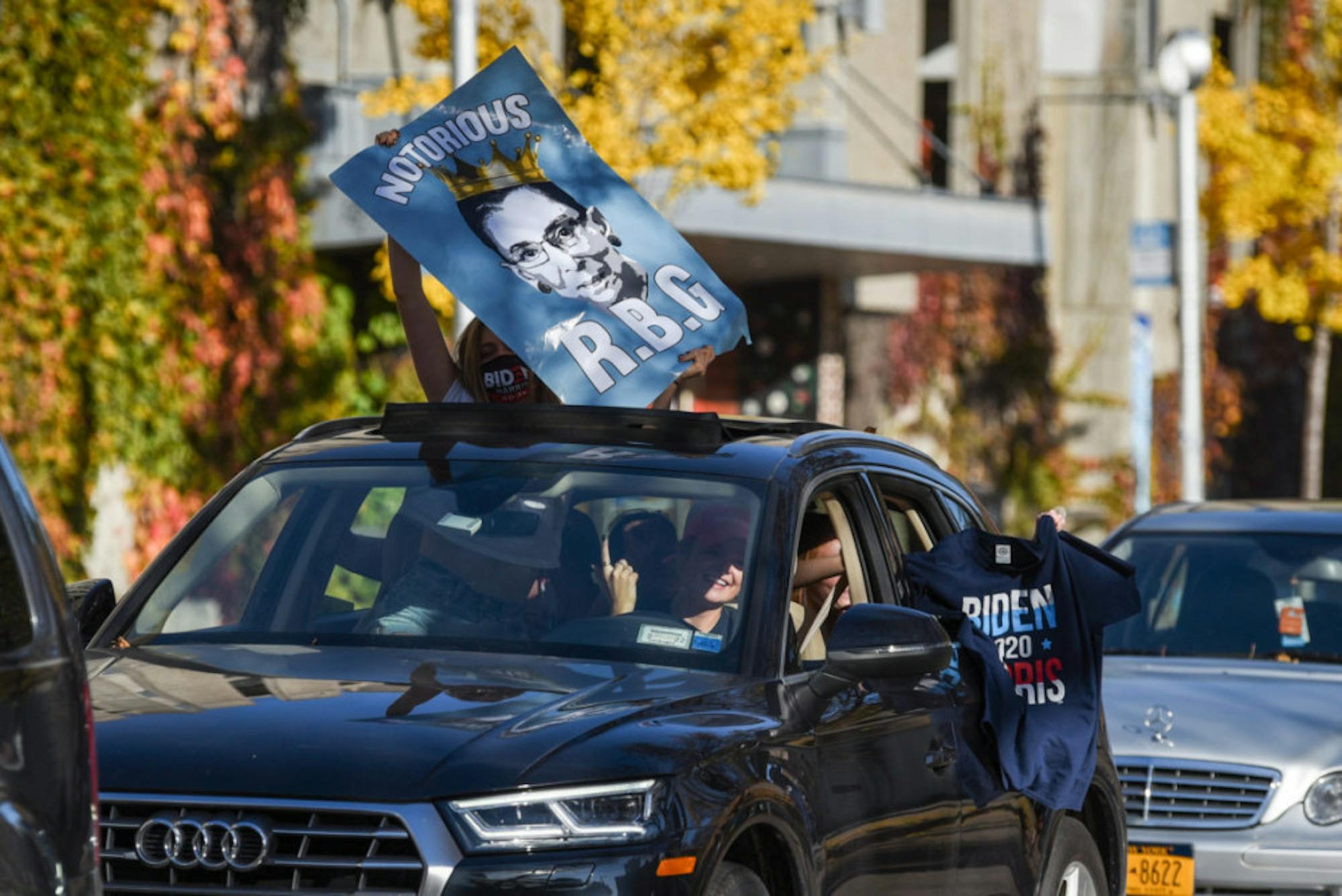 Students showed off “Fuck Trump” signs and Biden shirts through sunroofs to whoops from passersby in Collegetown.