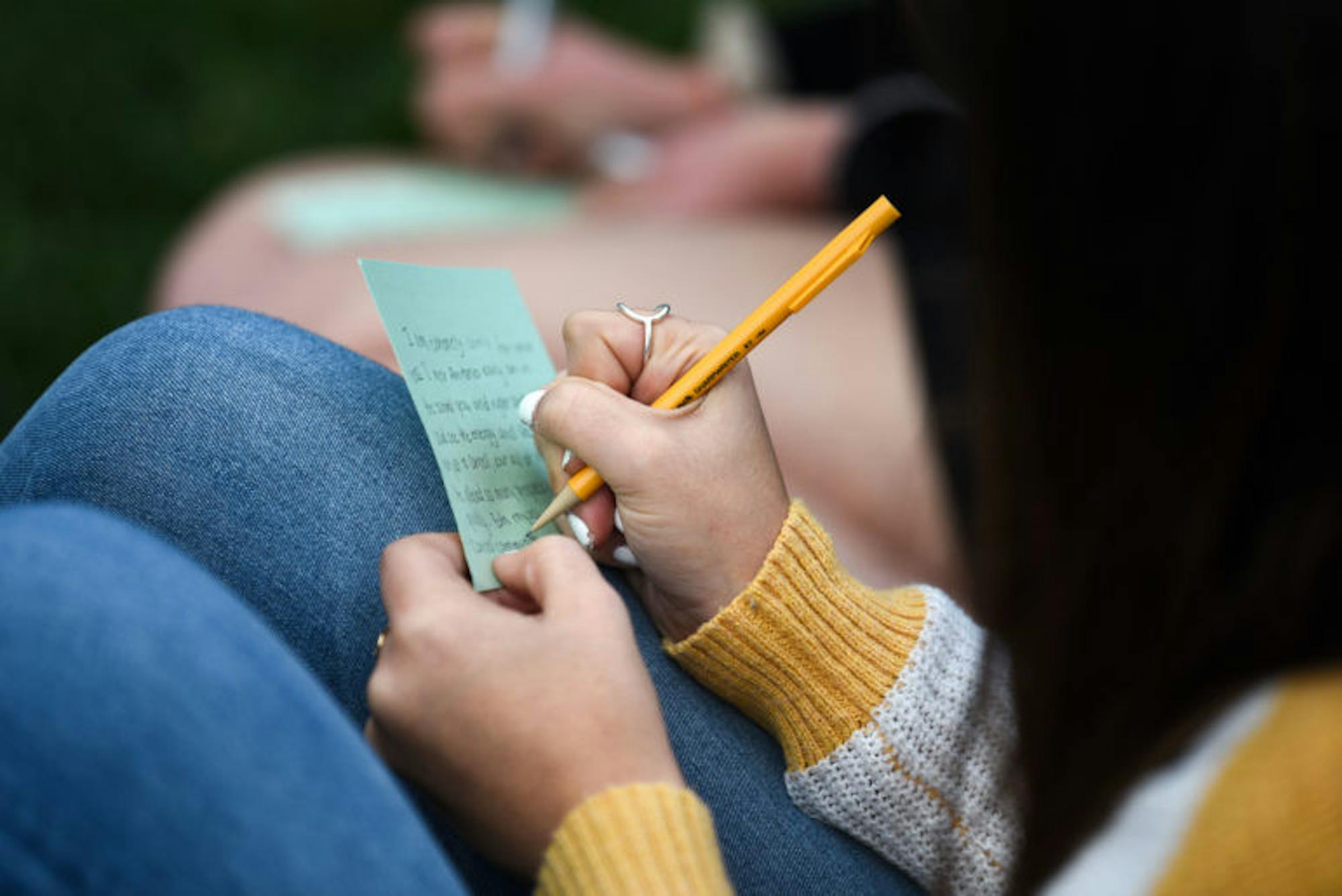 Students write letters to the family of Antonio Tsialas '23 on note cards outside Anabel Taylor Hall during the service of remembrance on October 29th, 2019.