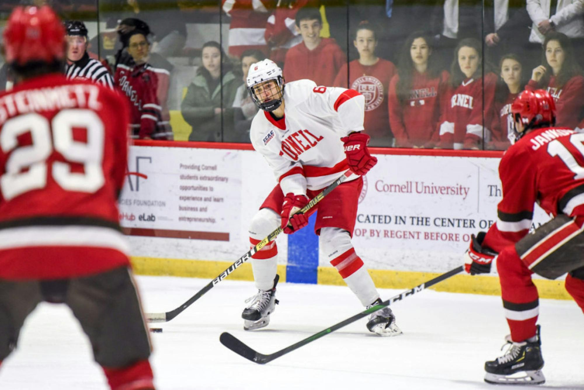 Junior defenseman Alex Green swipes the puck at the game against St. Lawrence on Friday. The game ended in a 5-0 Cornell win. (Boris Tsang/Sun Photography Editor)