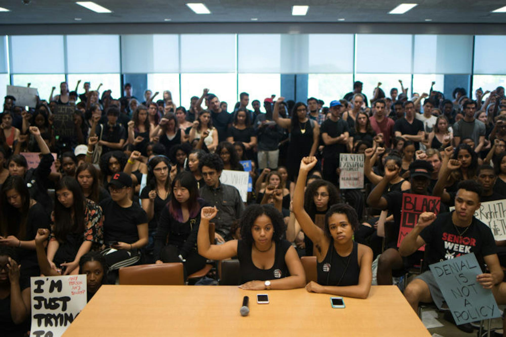 Traci Celestin and Delmar Fears, co-chairs of Black Students United, sit in silence and hold up their fists at a University Assembly meeting in Clark Hall, September 19th, 2017. (Cameron Pollack / Sun Photography Editor)
