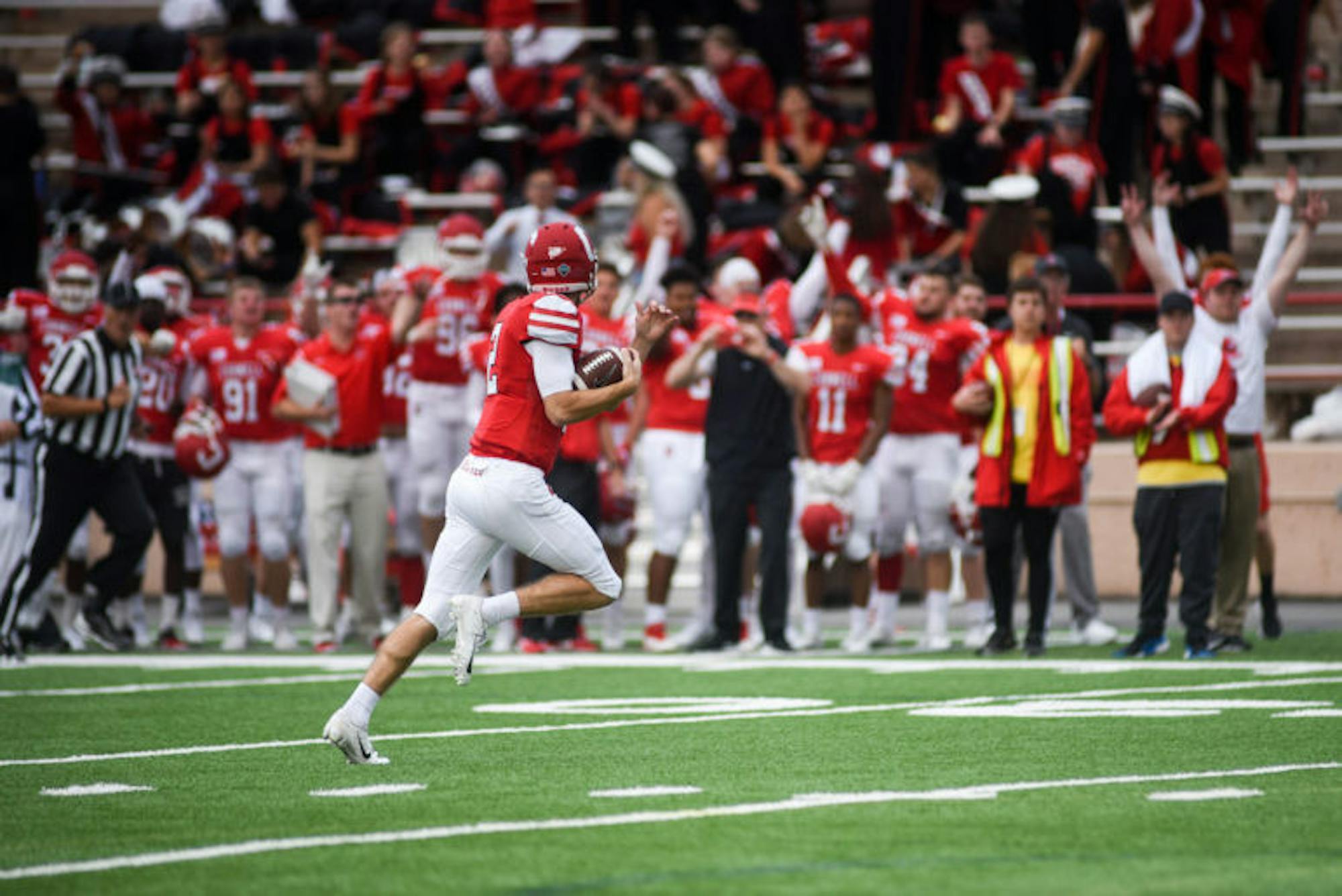 The crowd cheers on junior quarterback Mike Catanese as he makes his way to the endzone for a touchdown, tying the game 14-14. Catanese's rushes played an important role in the Red's comeback victory over Harvard. (Boris Tsang / Sun Assistant Photography Editor)