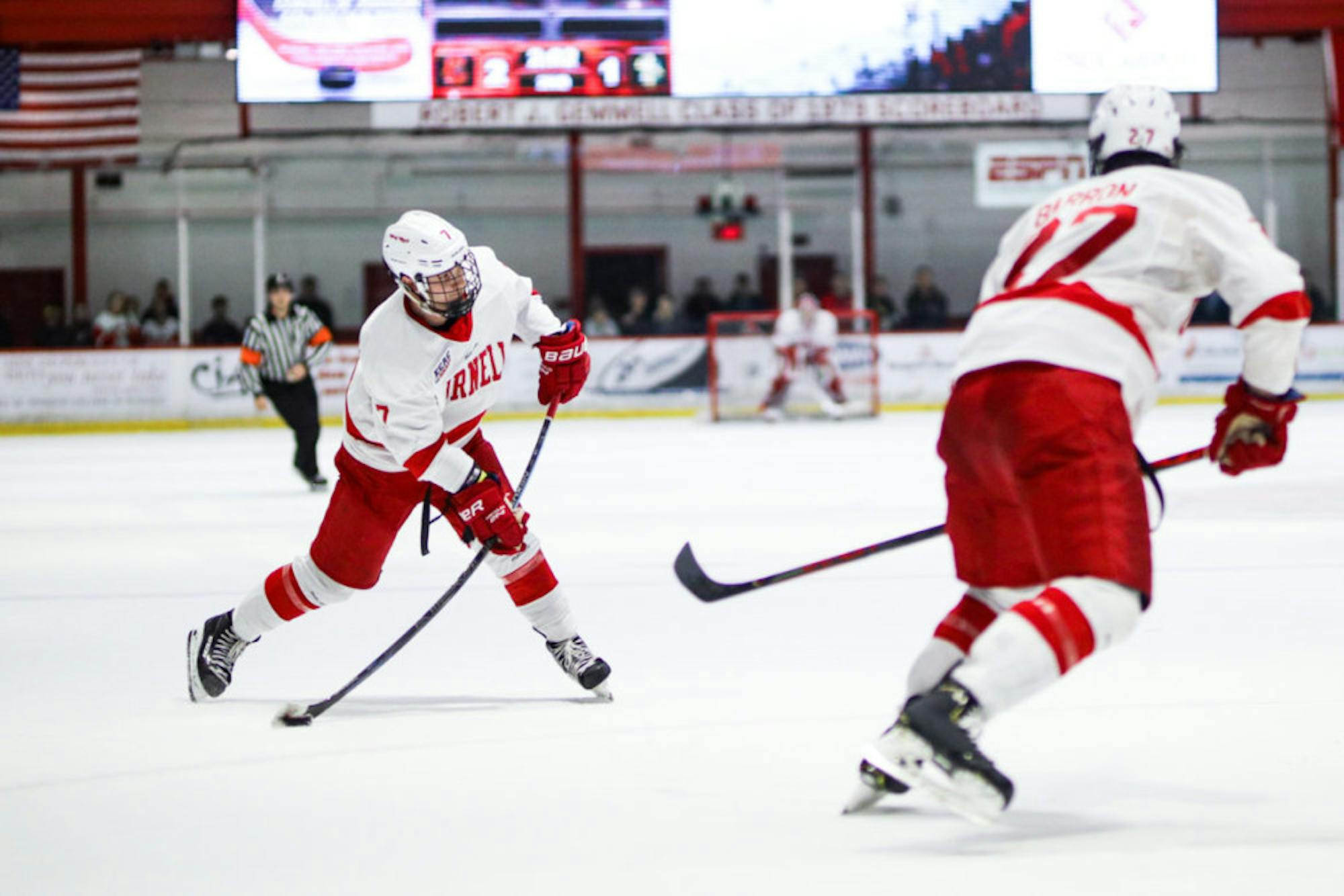 Junior forward Cam Donaldson passes the puck to teammate, junior forward Morgan Barron, at the men's hockey game against Clarkson on Saturday. Securing a 5-1 win, the Red will return to the Lynah rink on March 13 for the ECAC Tournament.(Michael Wenye Li/Sun Senior Photographer)