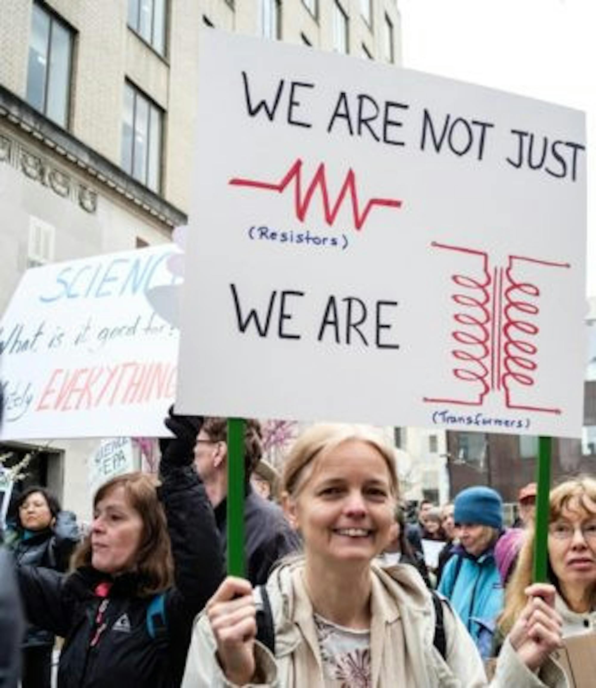 A demonstrator holds up a creative sign.